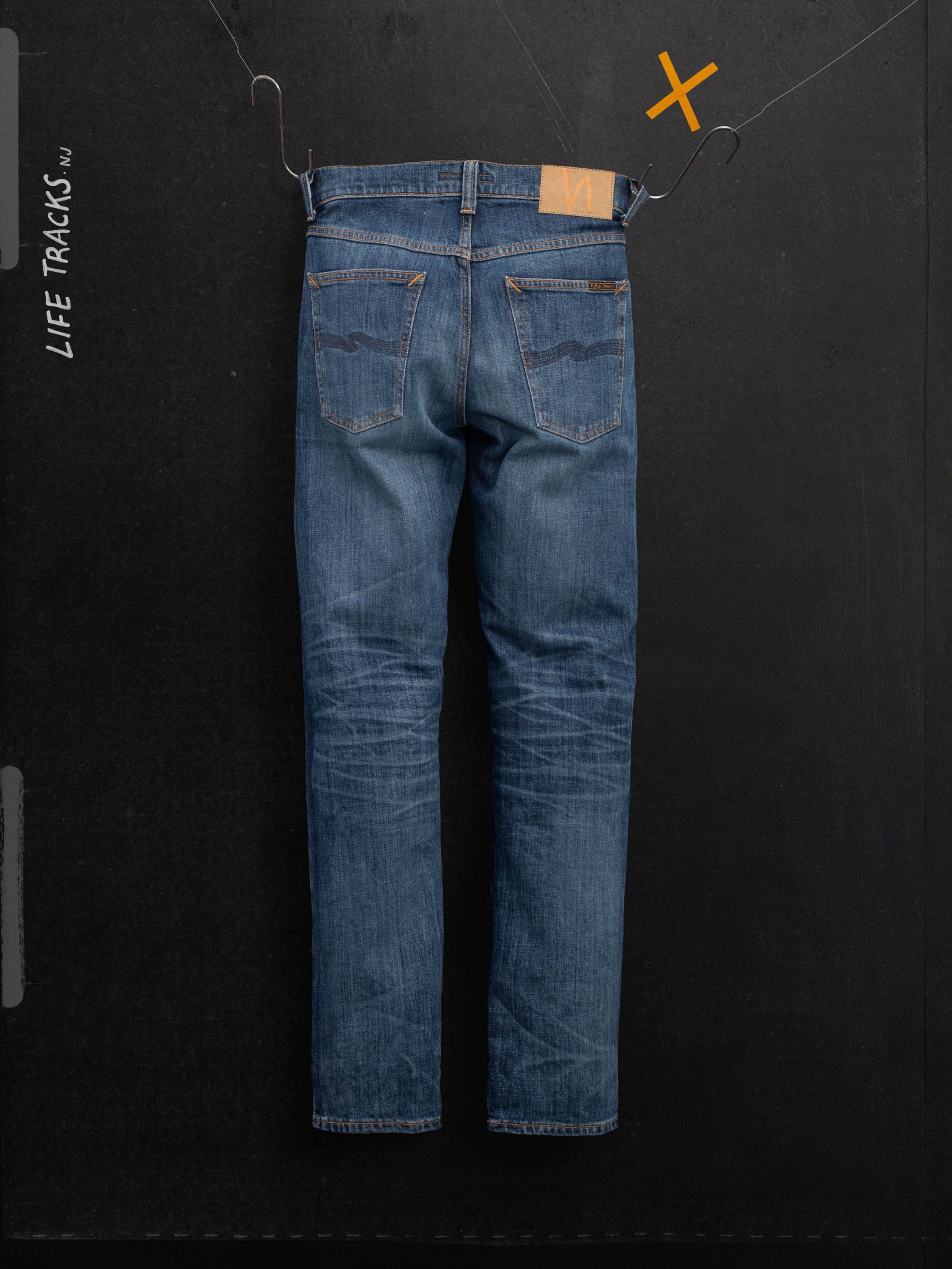 Nudie Jeans Solid Ollie Blue Echo Tracks, slim fit organic cotton comfort stretch jeans with honeycomb fades, back view.