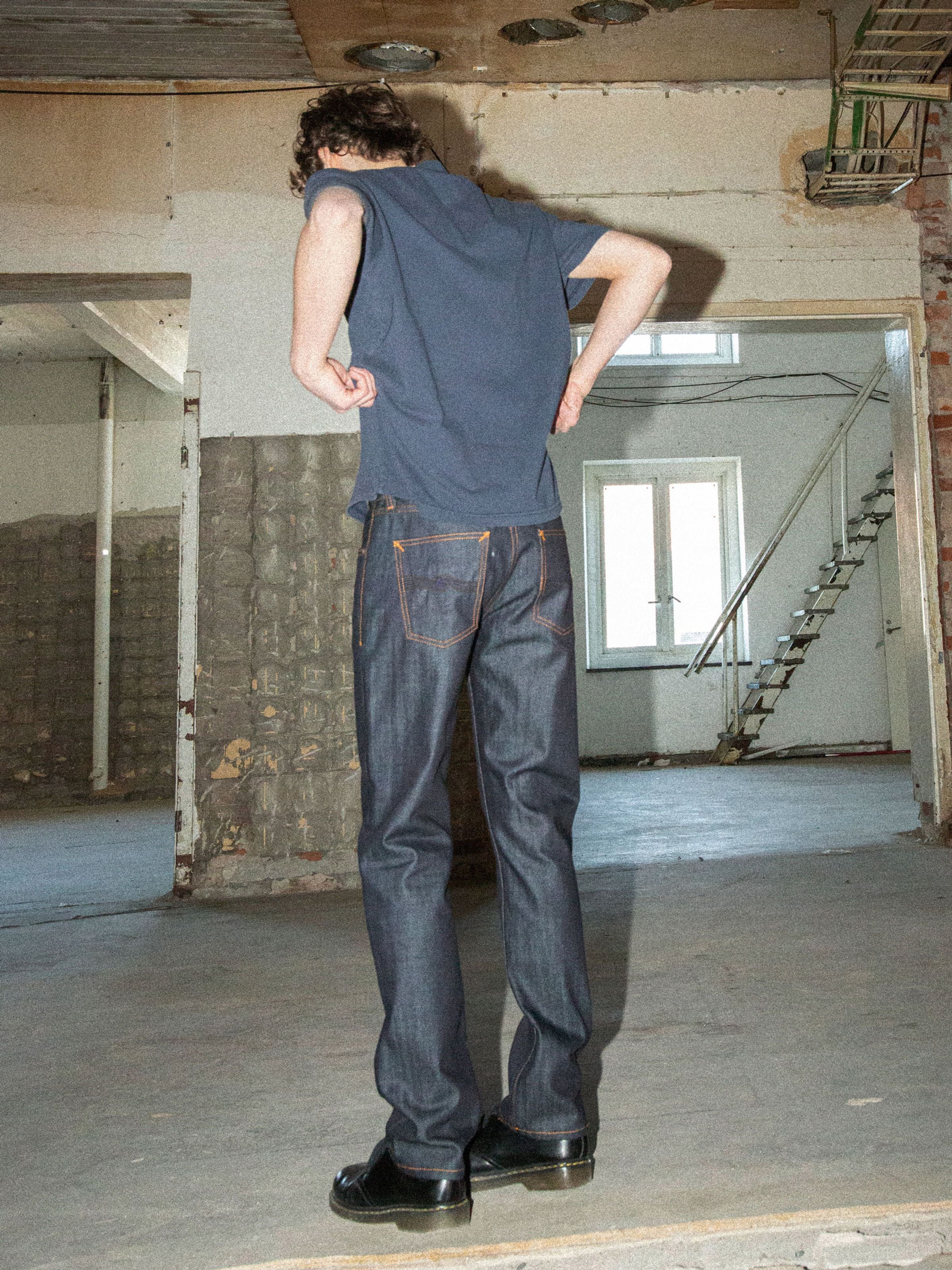 Nudie Jeans Gritty Jackson Blue Dry Two, regular fit organic cotton jeans with orange stitching, shown from the back.