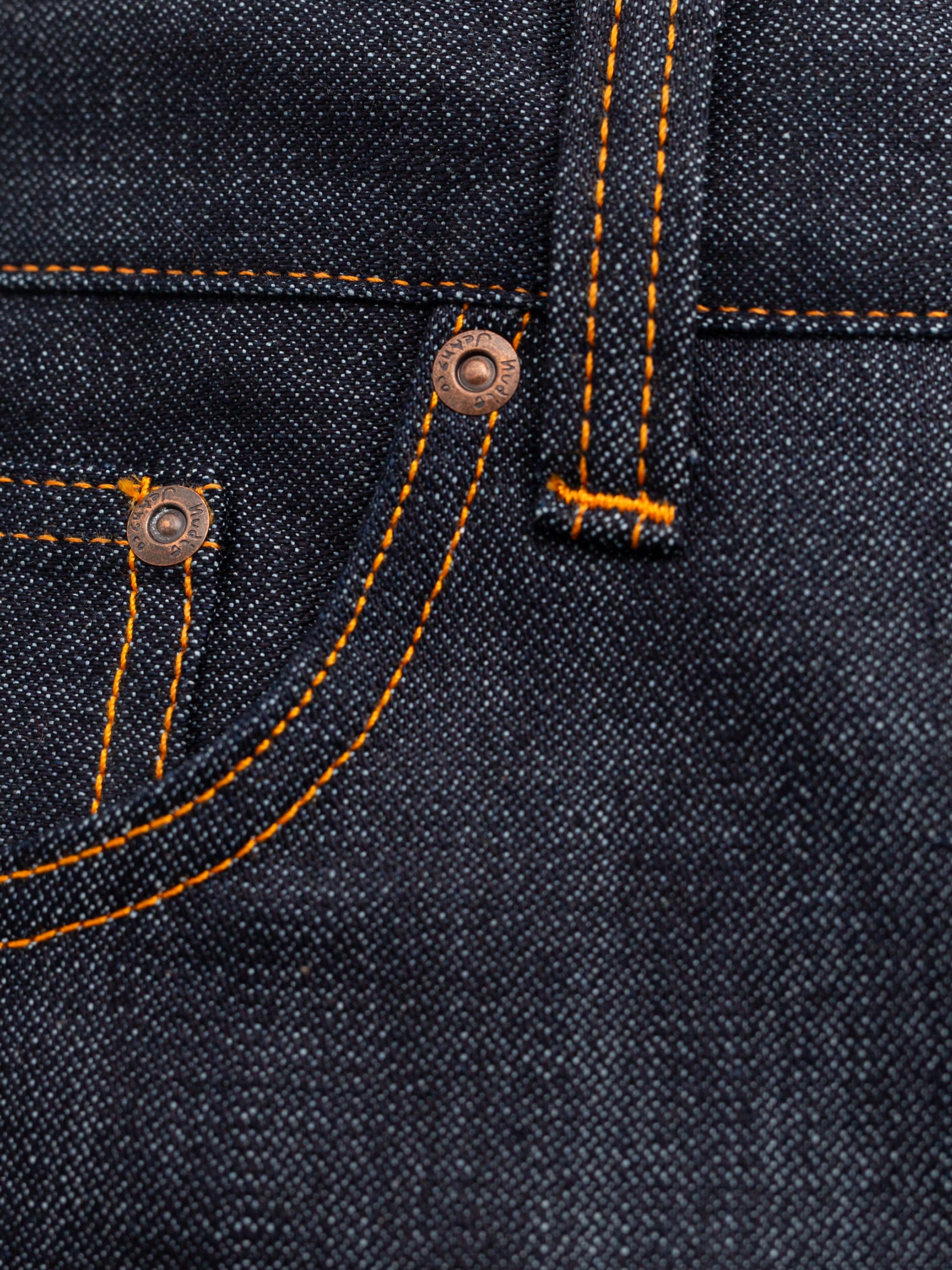 Nudie Jeans Gritty Jackson Blue Dry Two, close-up of orange stitching and copper rivets on blue organic cotton denim.