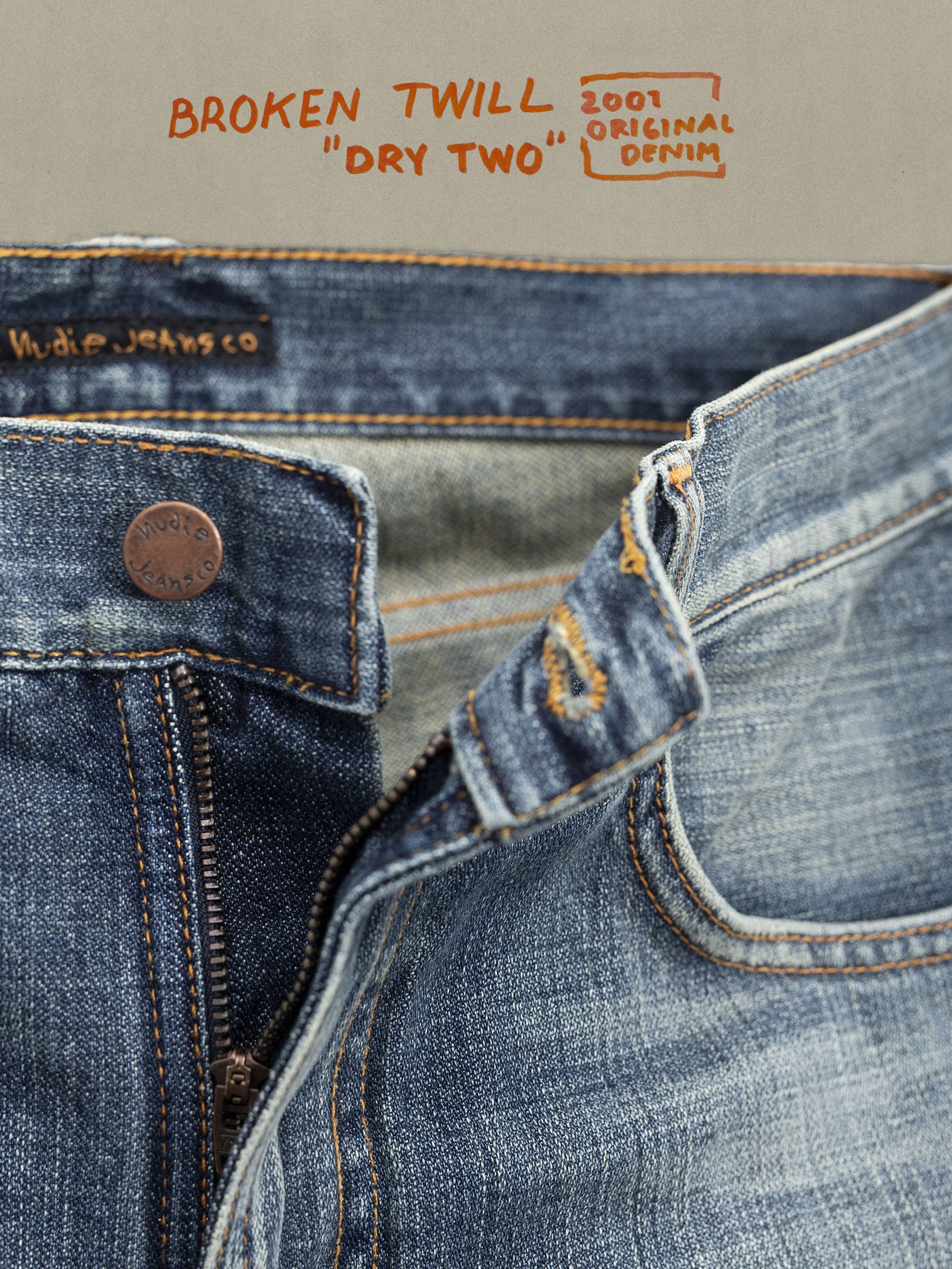 Nudie Jeans Gritty Jackson Tidal Waves, Nahaufnahme vom mittelblauen Broken Twill Denim aus Bio-Baumwolle mit Reißverschluss.