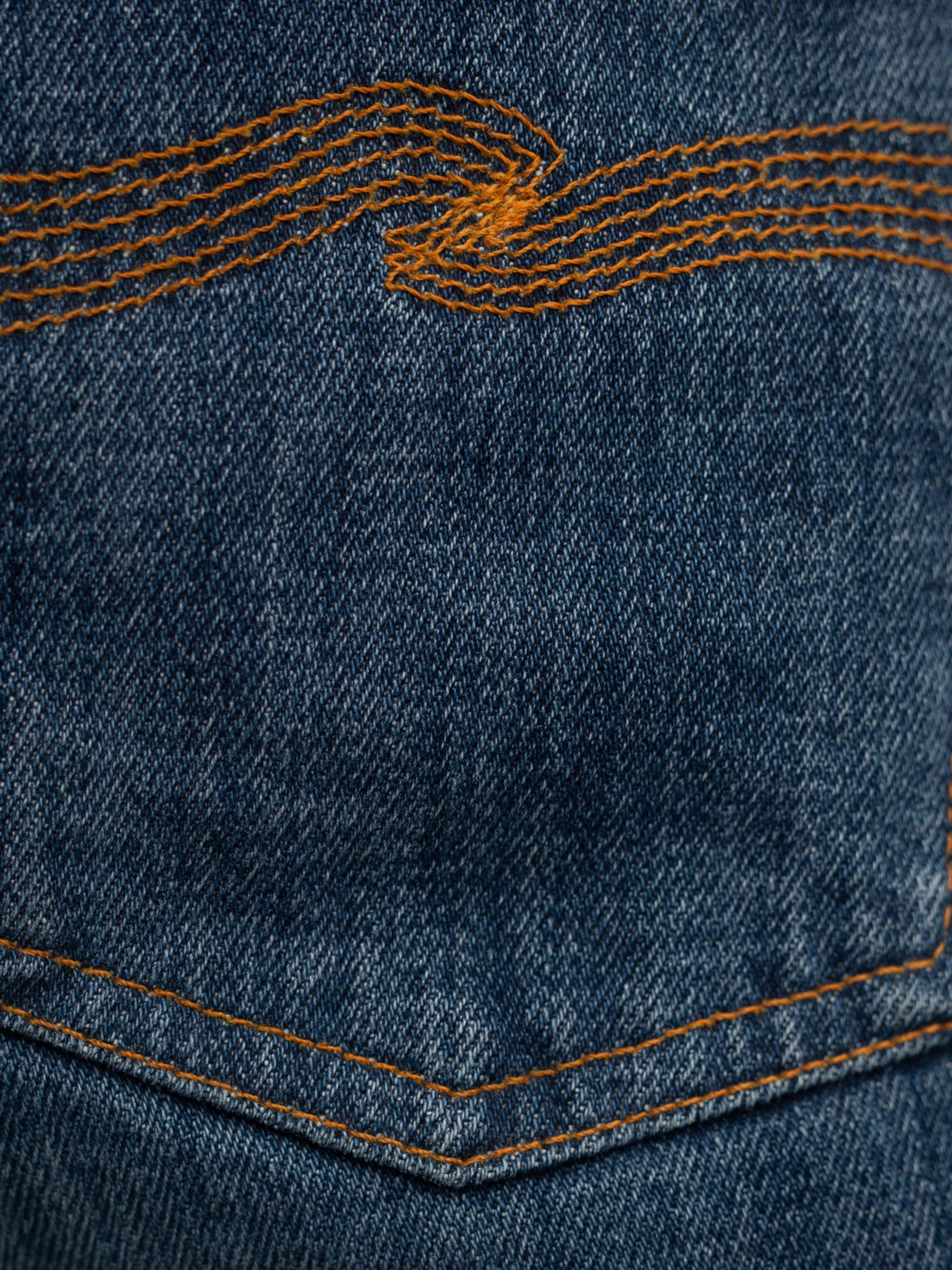 Nudie Jeans Lean Dean Echo Tracks, back pocket with signature orange embroidery on dark blue organic cotton denim.