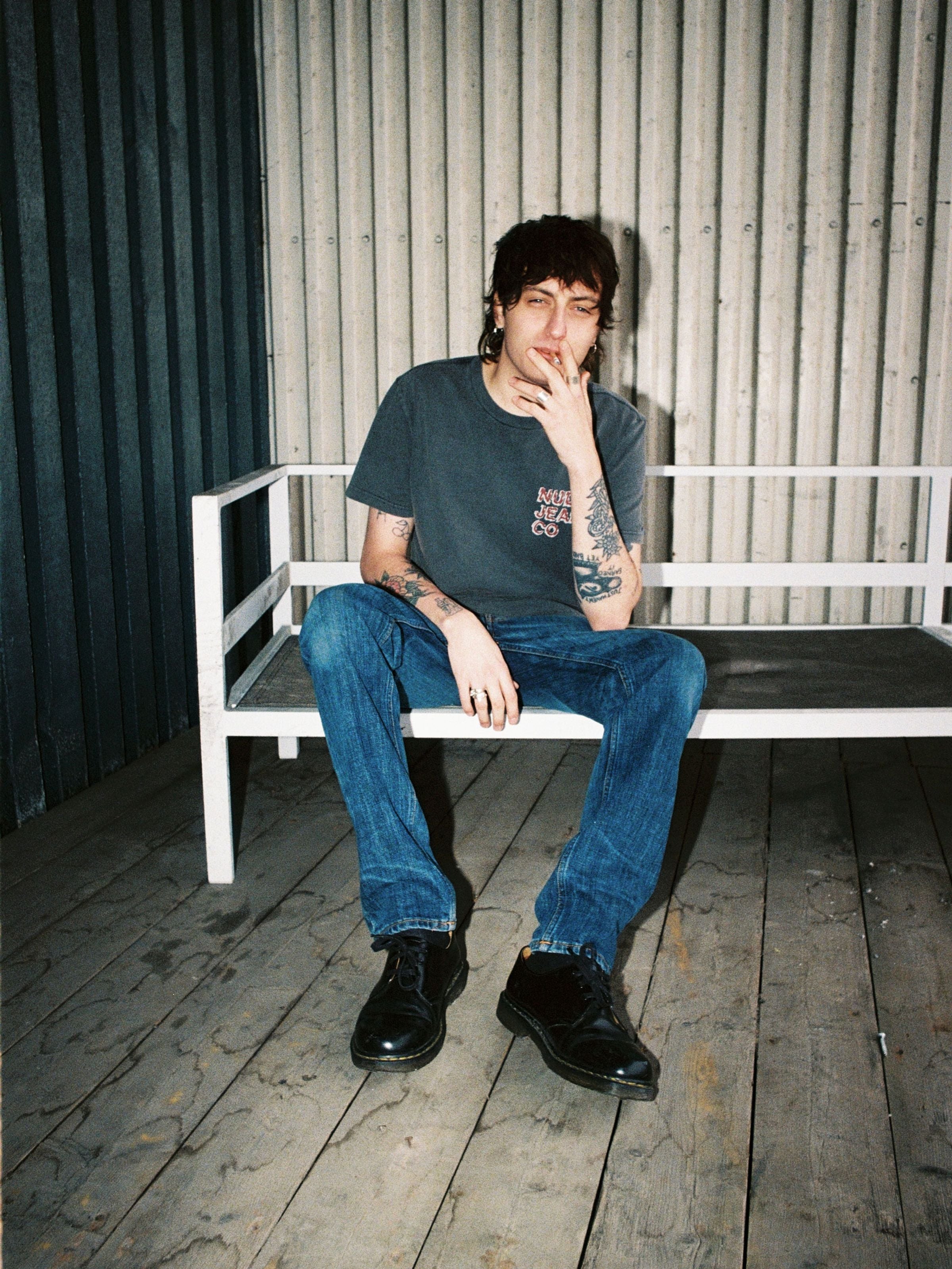 Nudie Jeans Lean Dean Echo Tracks, slim tapered organic cotton jeans in a dark blue wash, shown on a seated model.