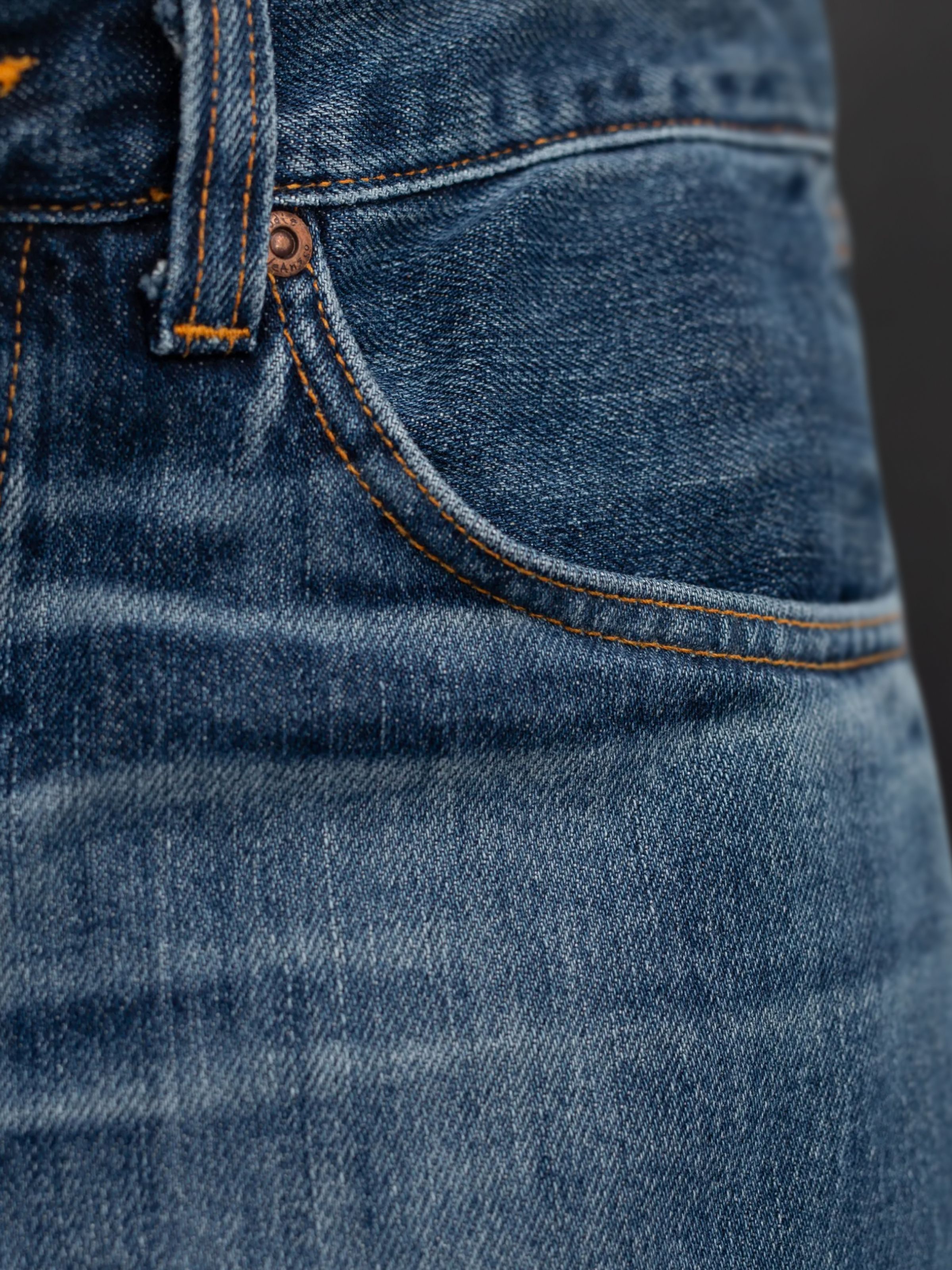 Nudie Jeans Steady Eddie II Twisted Tracks, Nahaufnahme der Vordertasche aus indigoblauem Rigid Denim aus Bio-Baumwolle.