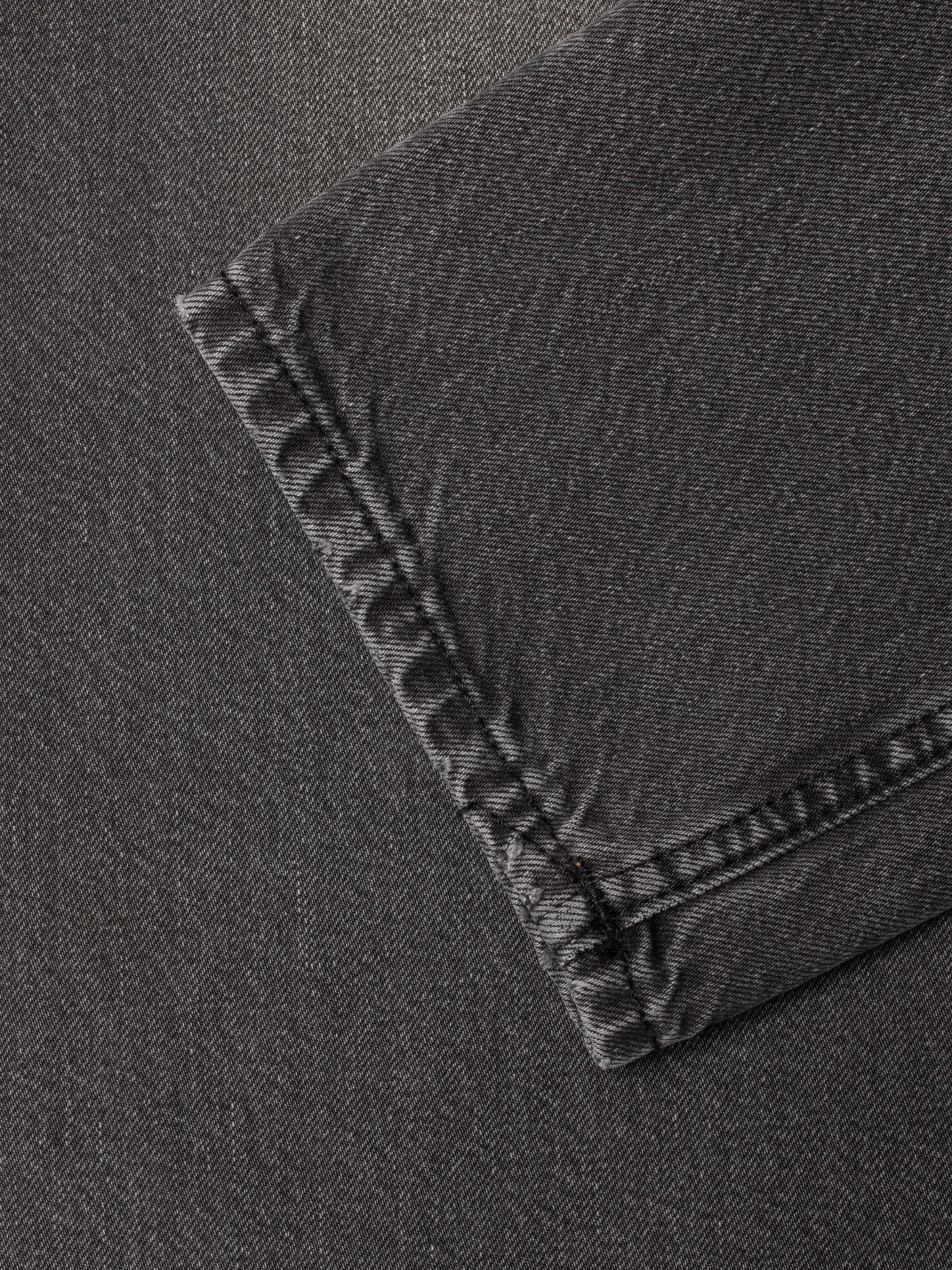 Nudie Jeans Gritty Jackson Grey Lake, a close-up of the leg opening hem in grey organic cotton rigid denim.