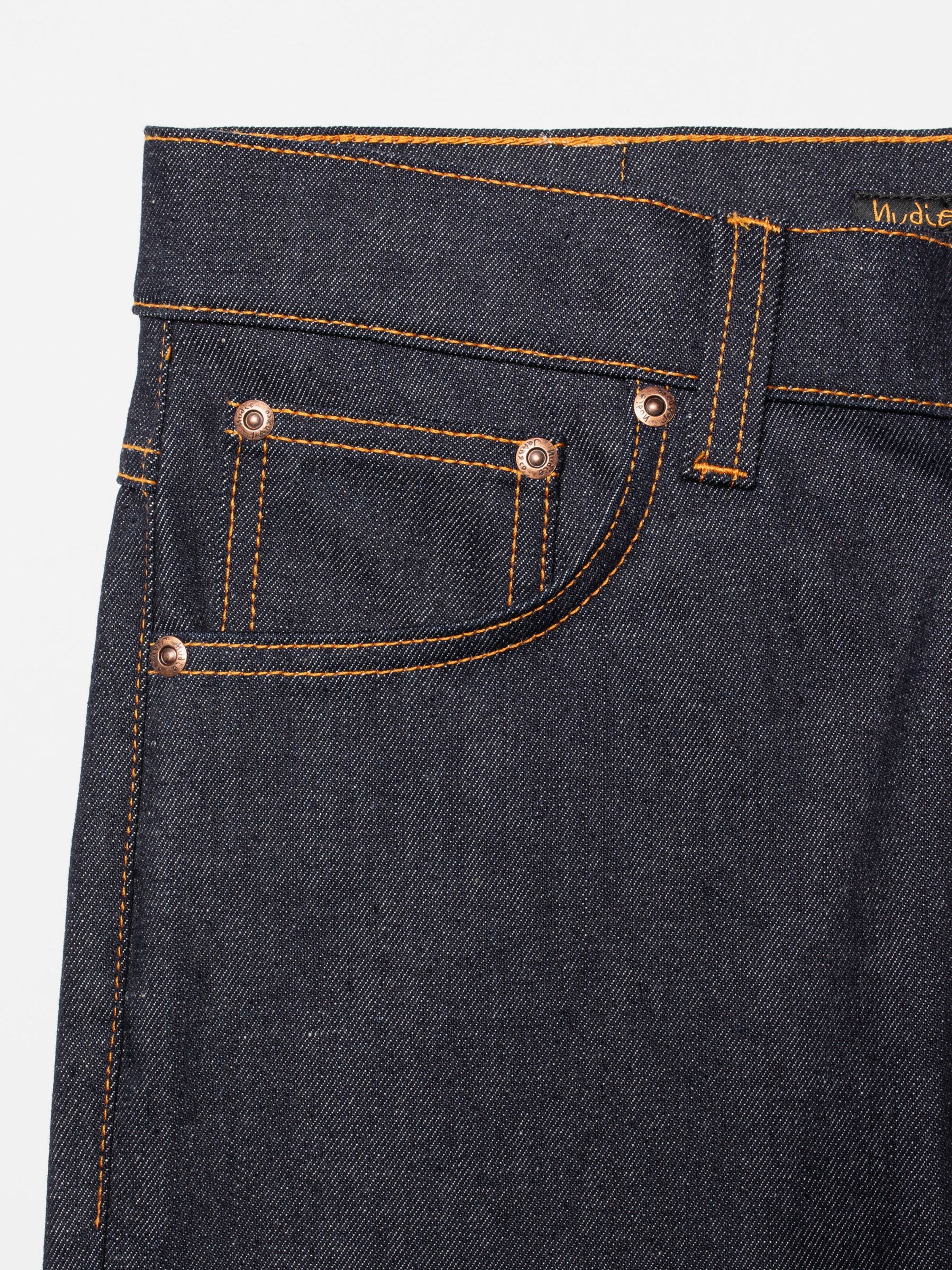 Nudie Jeans Grim Tim Dry Blue 16 Dips, close-up of the front pocket and copper rivets on organic cotton denim.