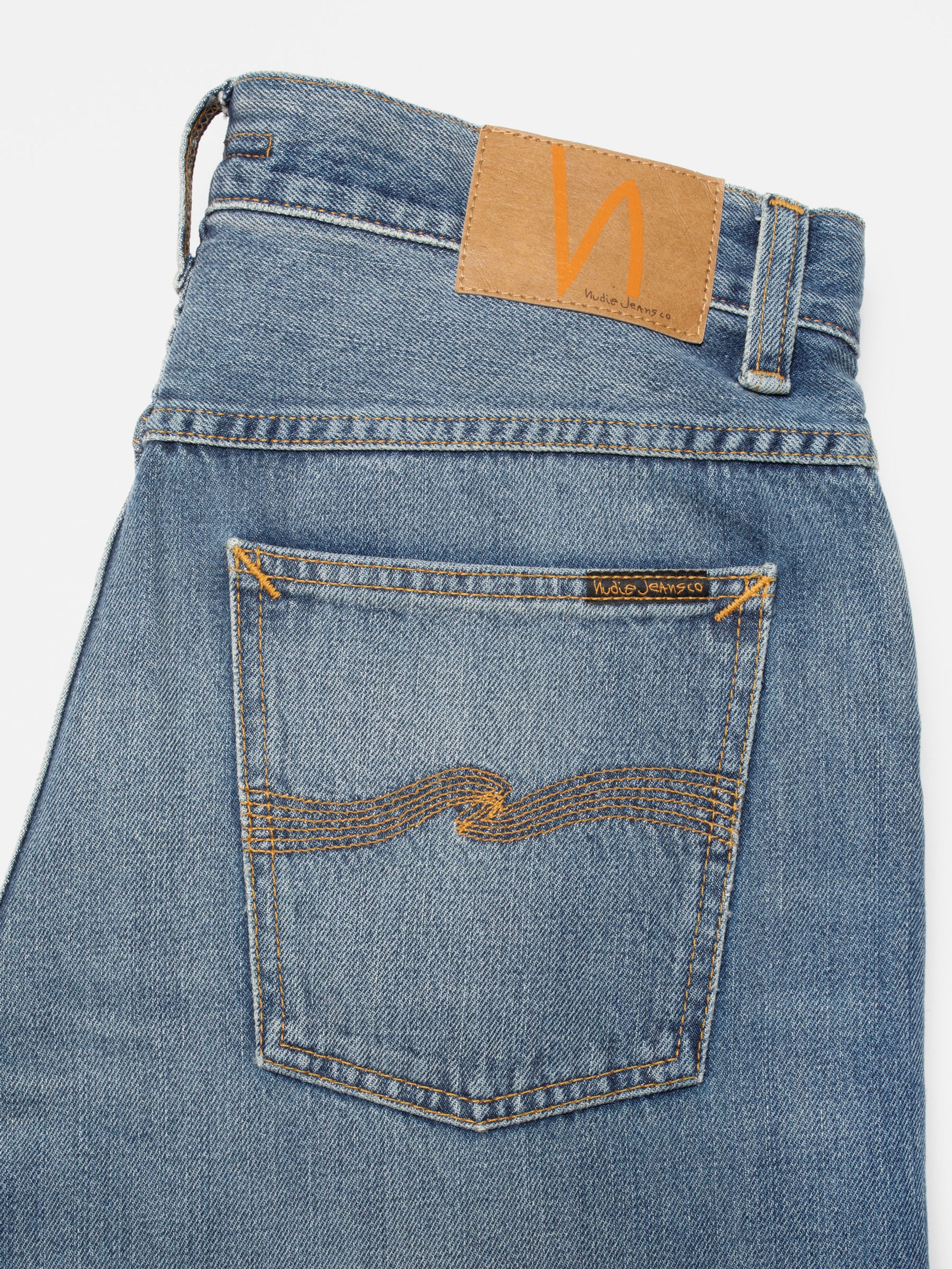 Nudie Jeans Loud Larry Gravel Stone, mid-blue organic cotton jeans showing the back pocket and tan Jacron patch.