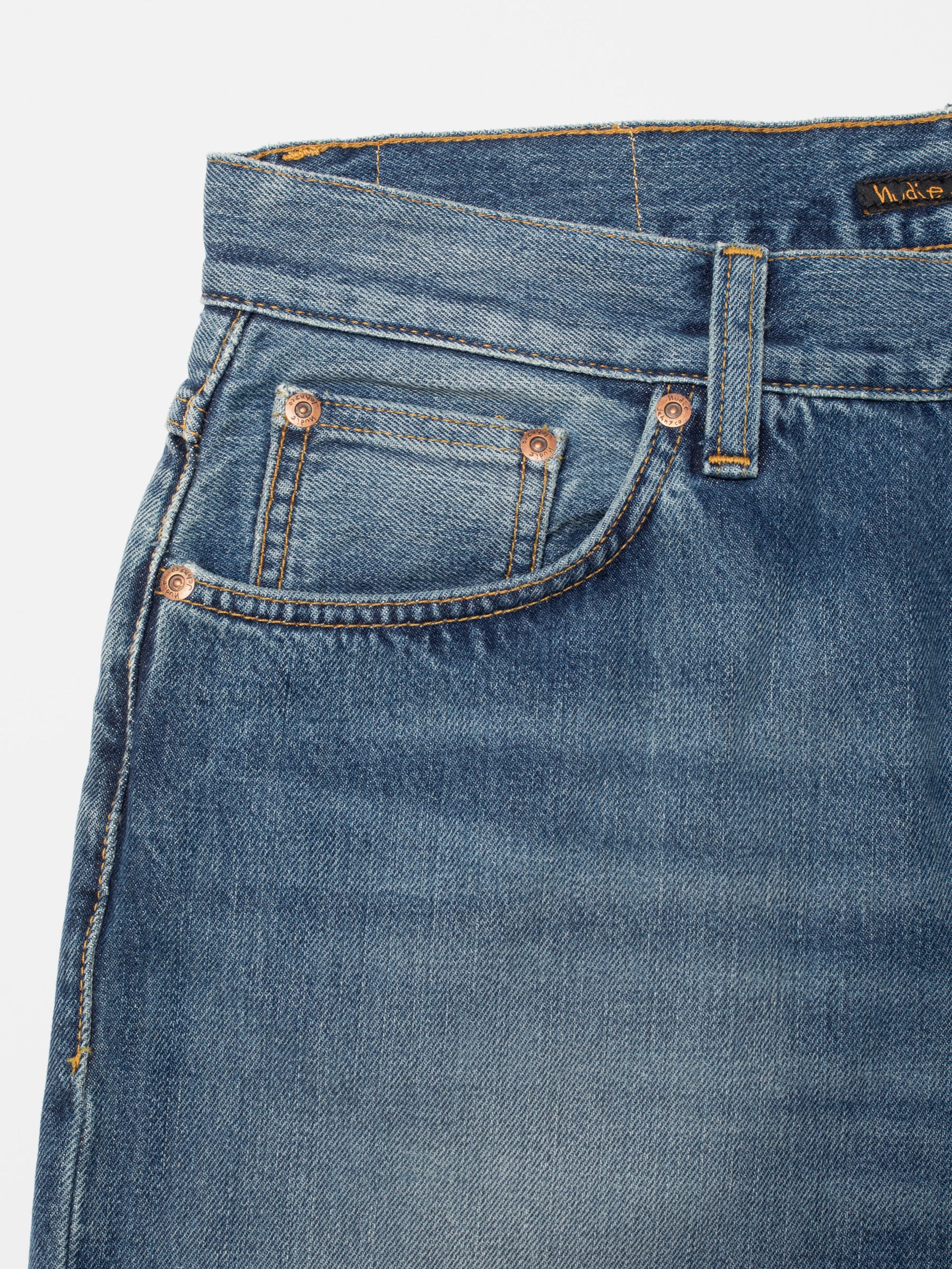 Nudie Jeans Loud Larry Gravel Stone, close-up of the front pocket and copper trims on mid-blue organic cotton denim.