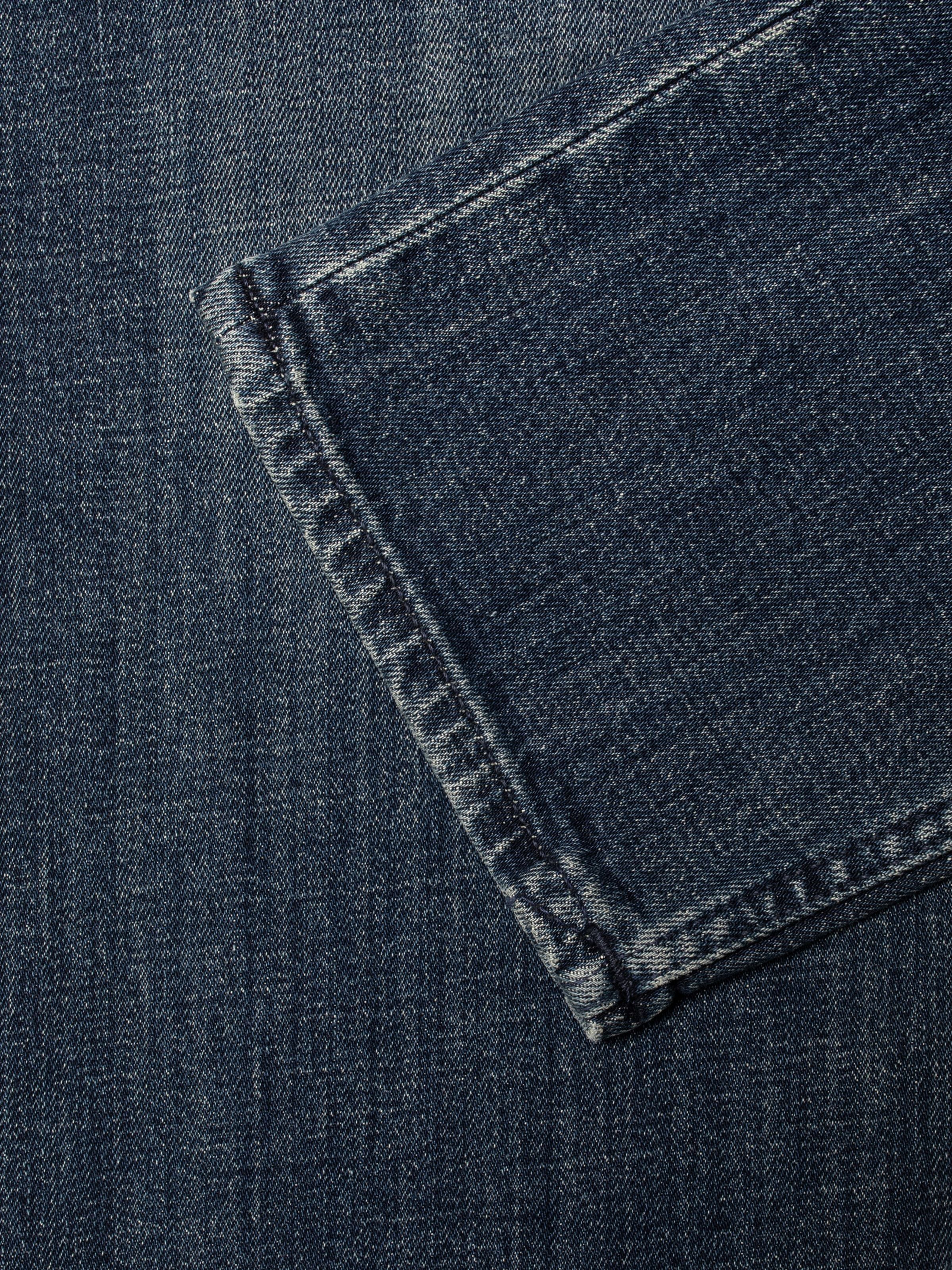 Nudie Jeans Solid Ollie Epic Ink, close-up of the straight leg opening on dark blue organic regenerative cotton denim.