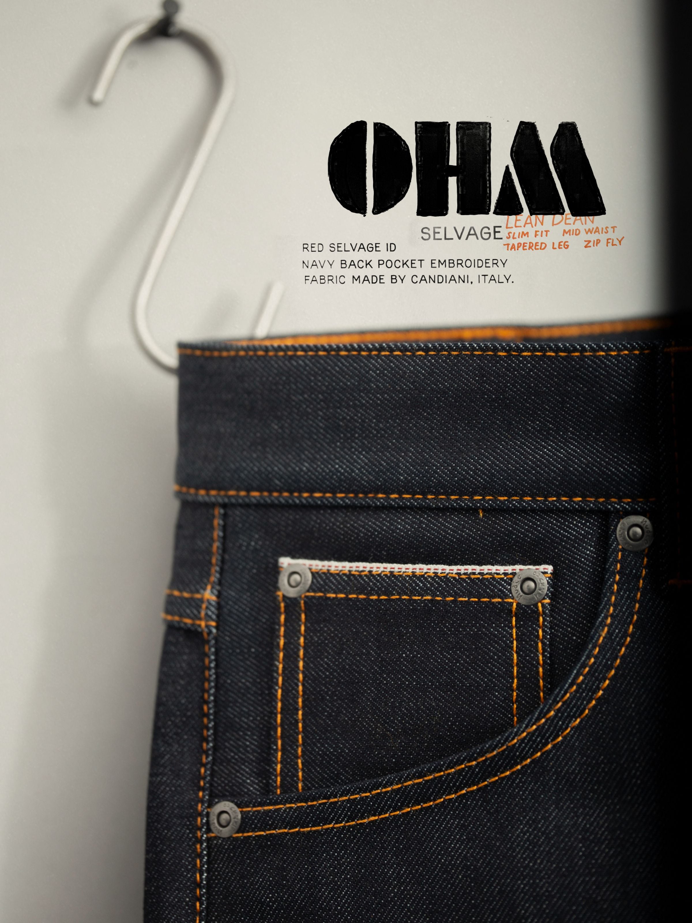 Nudie Jeans Lean Dean Dry Ohm Selvage, close-up of dark blue organic cotton selvedge denim, orange stitching and coin pocket.
