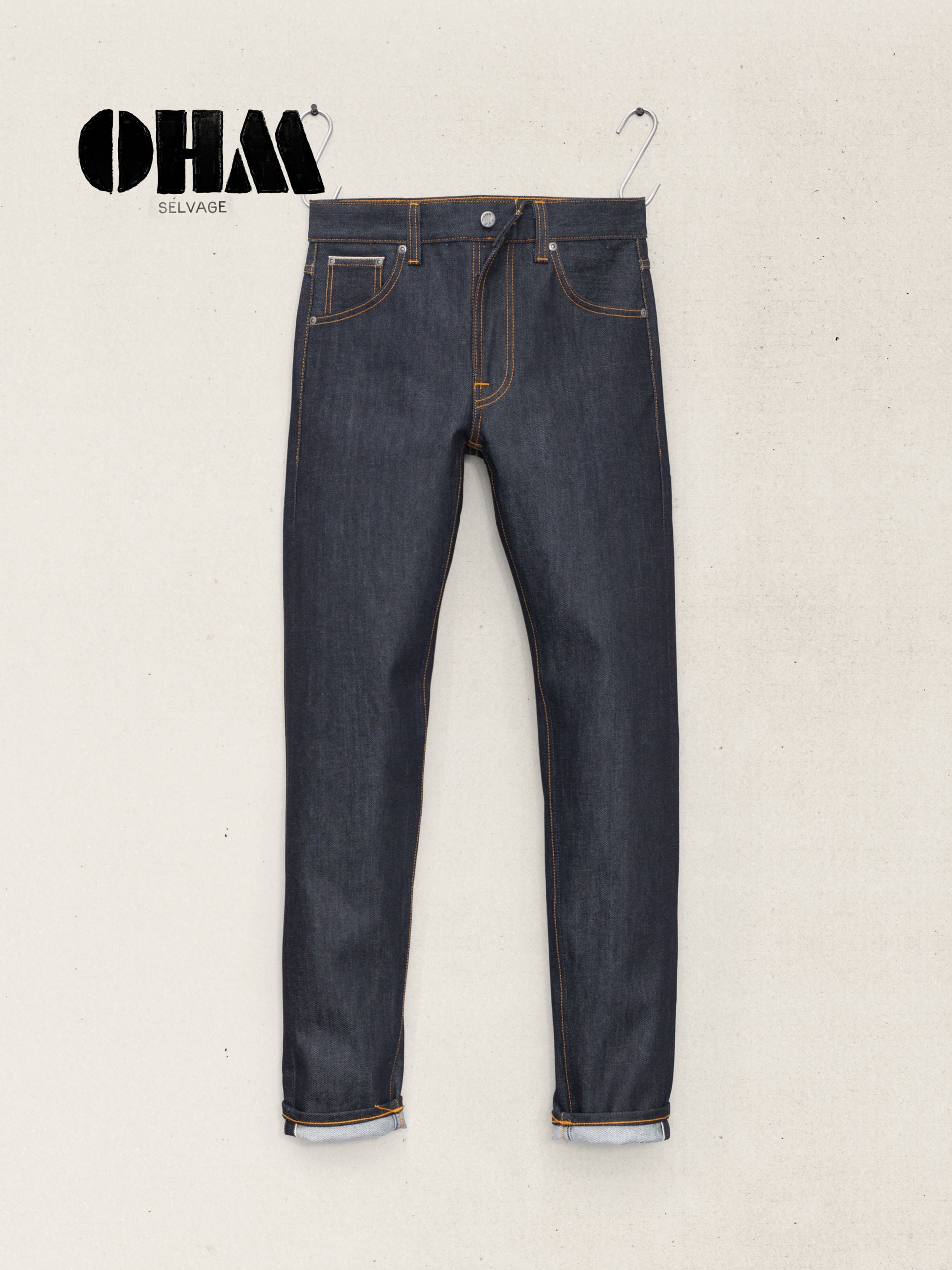 Nudie Jeans Lean Dean Dry Ohm Selvage, slim tapered organic cotton jeans in dry blue selvedge denim, shown laid flat.