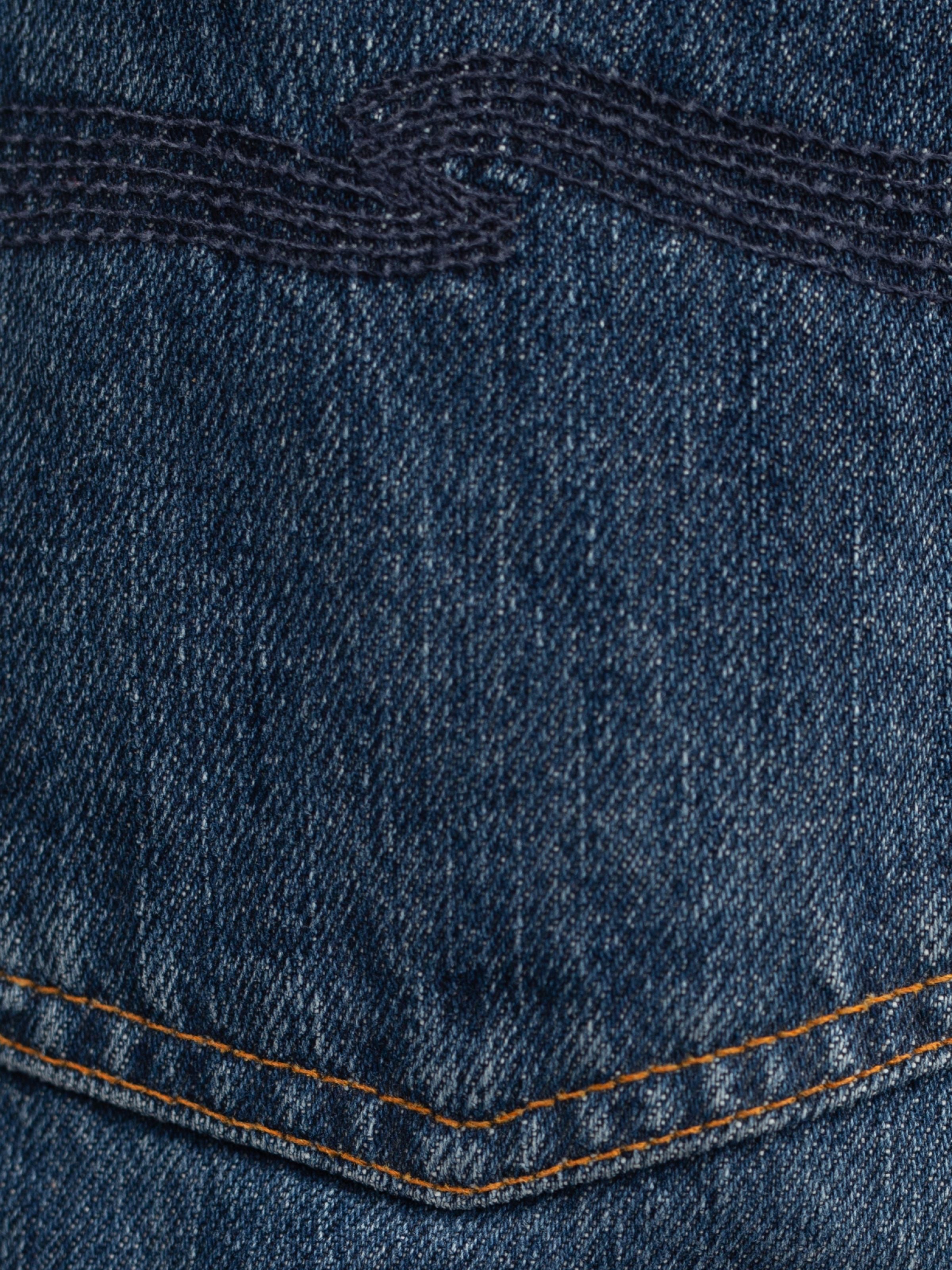 Nudie Jeans Rad Rufus Blue Twisted Tracks, a close-up of washed organic cotton denim with navy back pocket embroidery.