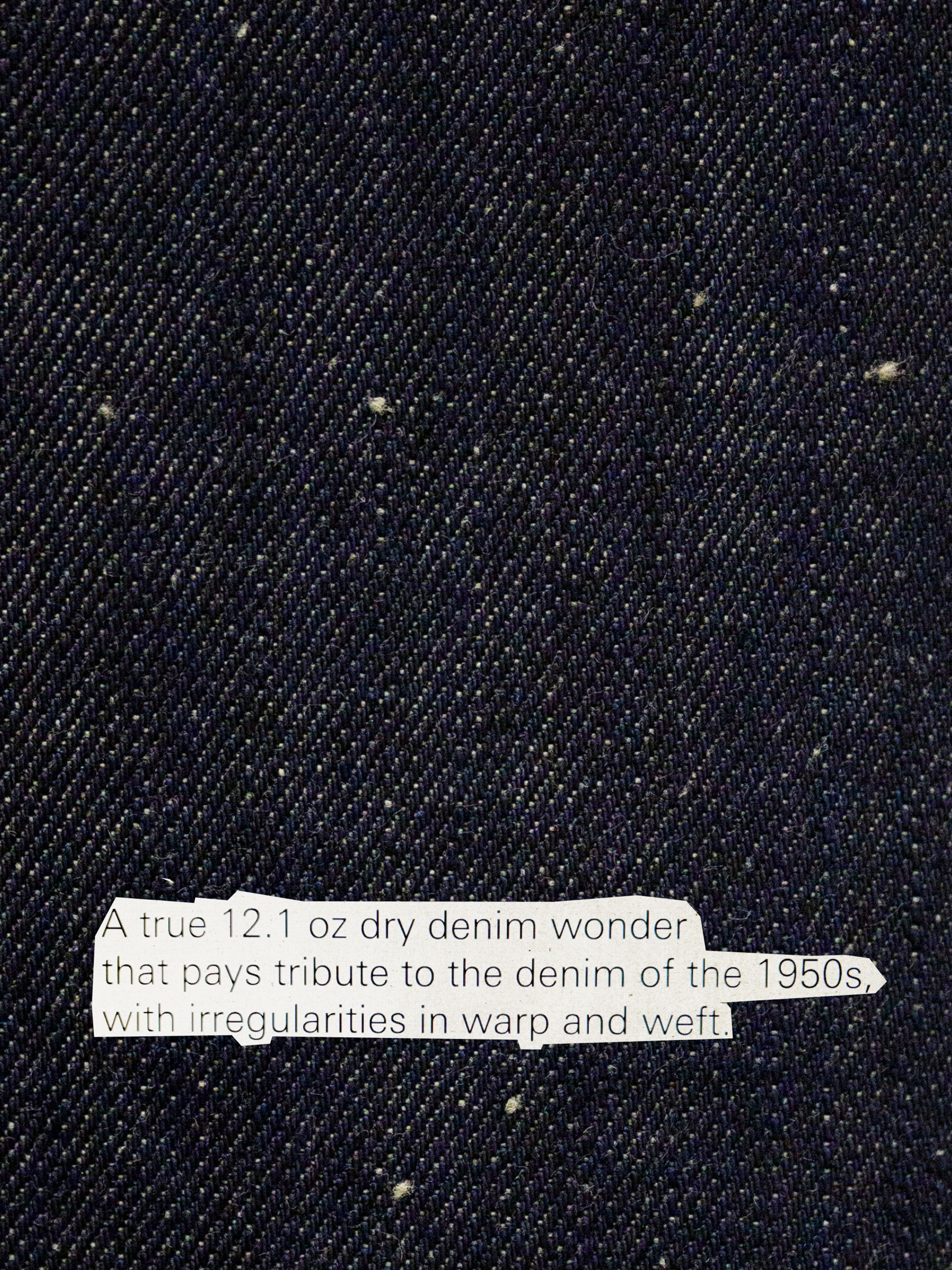Dusty Dee Dry Weird dark indigo denim close-up with visible neps and text describing the 12.1 oz 1950s-inspired fabric.