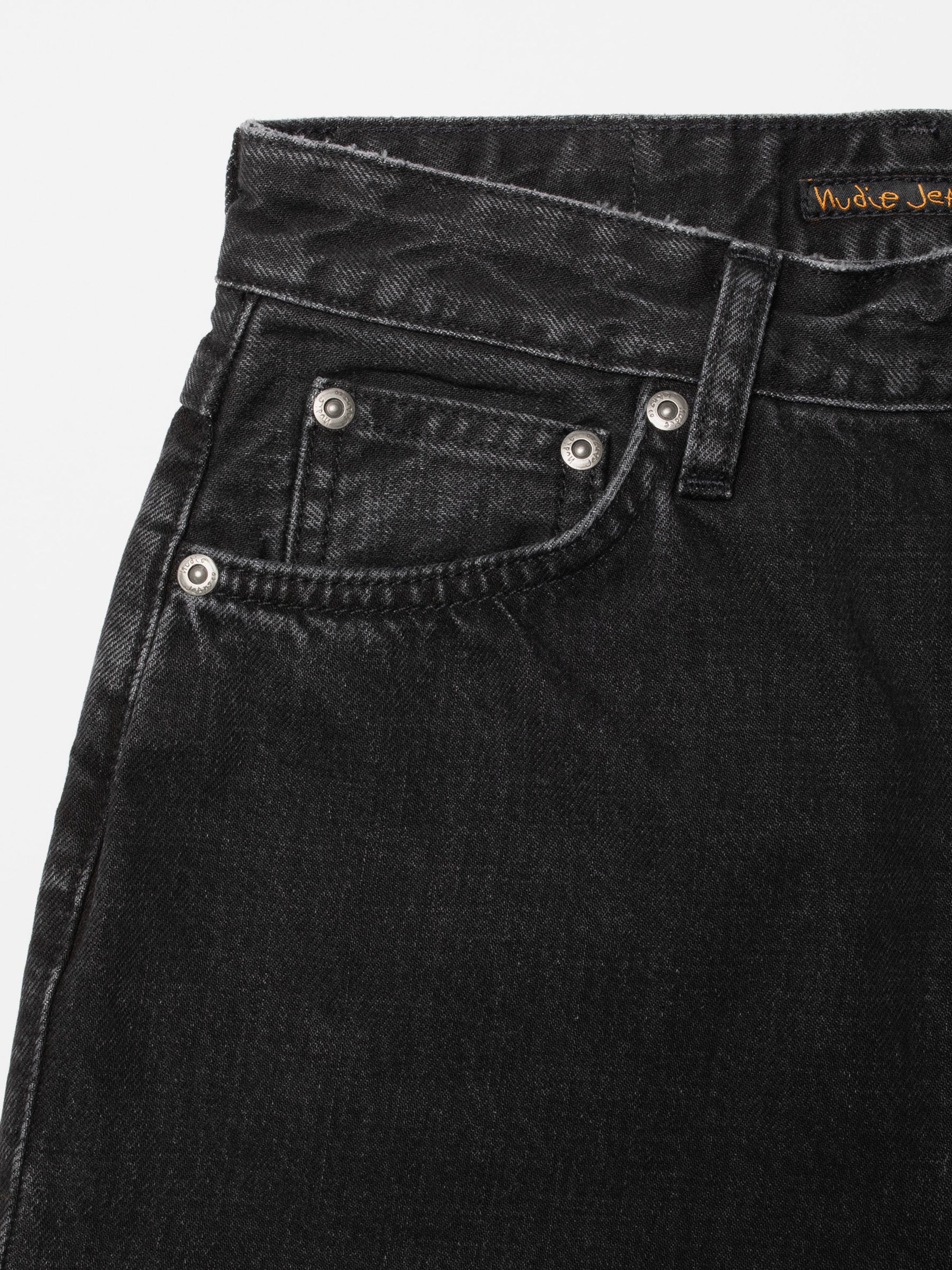 Nudie Jeans Breezy Britt Friendly Black, close-up of the front pocket and silver trims on organic cotton rigid denim.