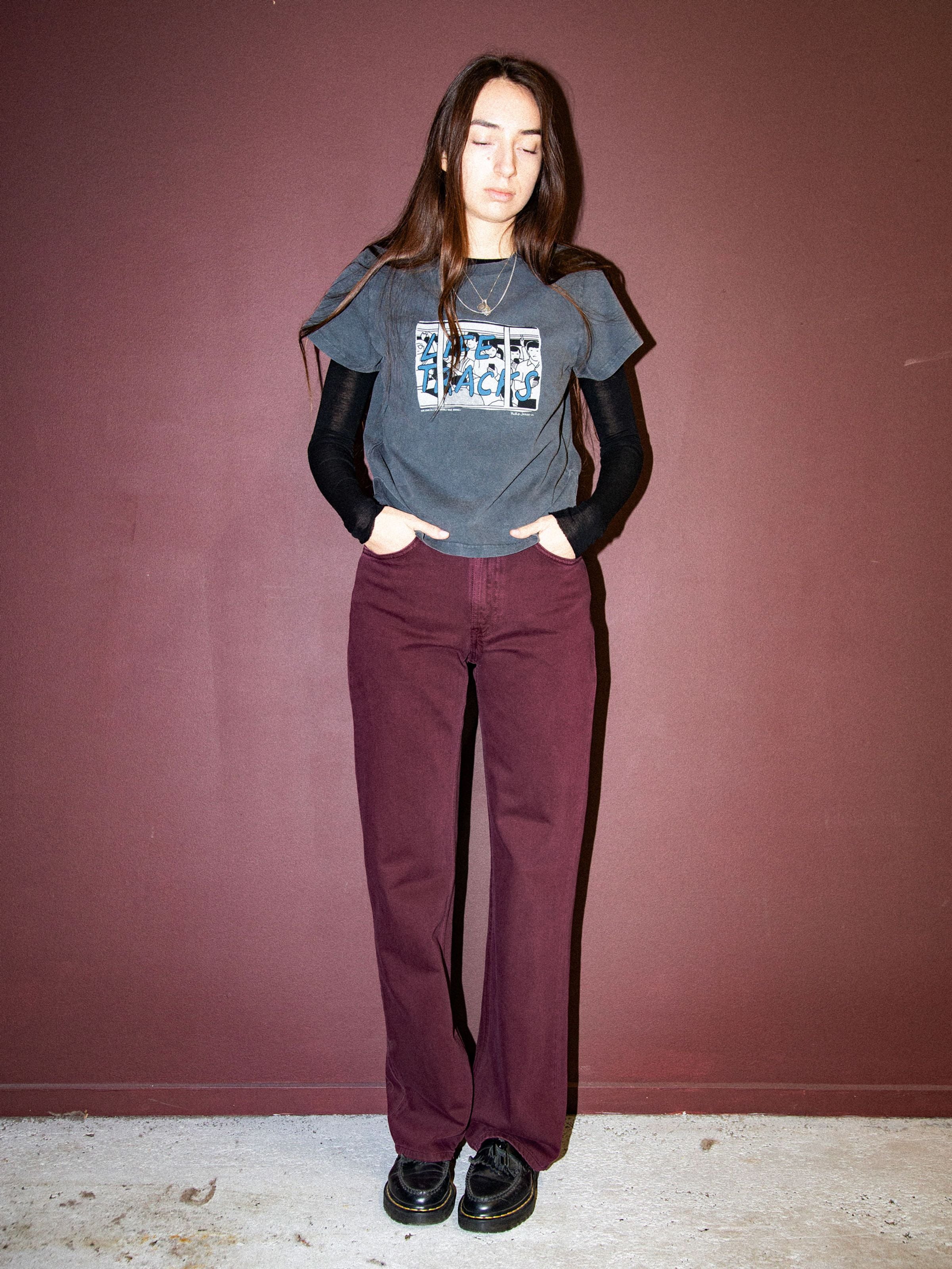 Nudie Jeans Clean Eileen Burgundy, high-waist wide-leg organic cotton jeans, shown on a model against a burgundy wall.