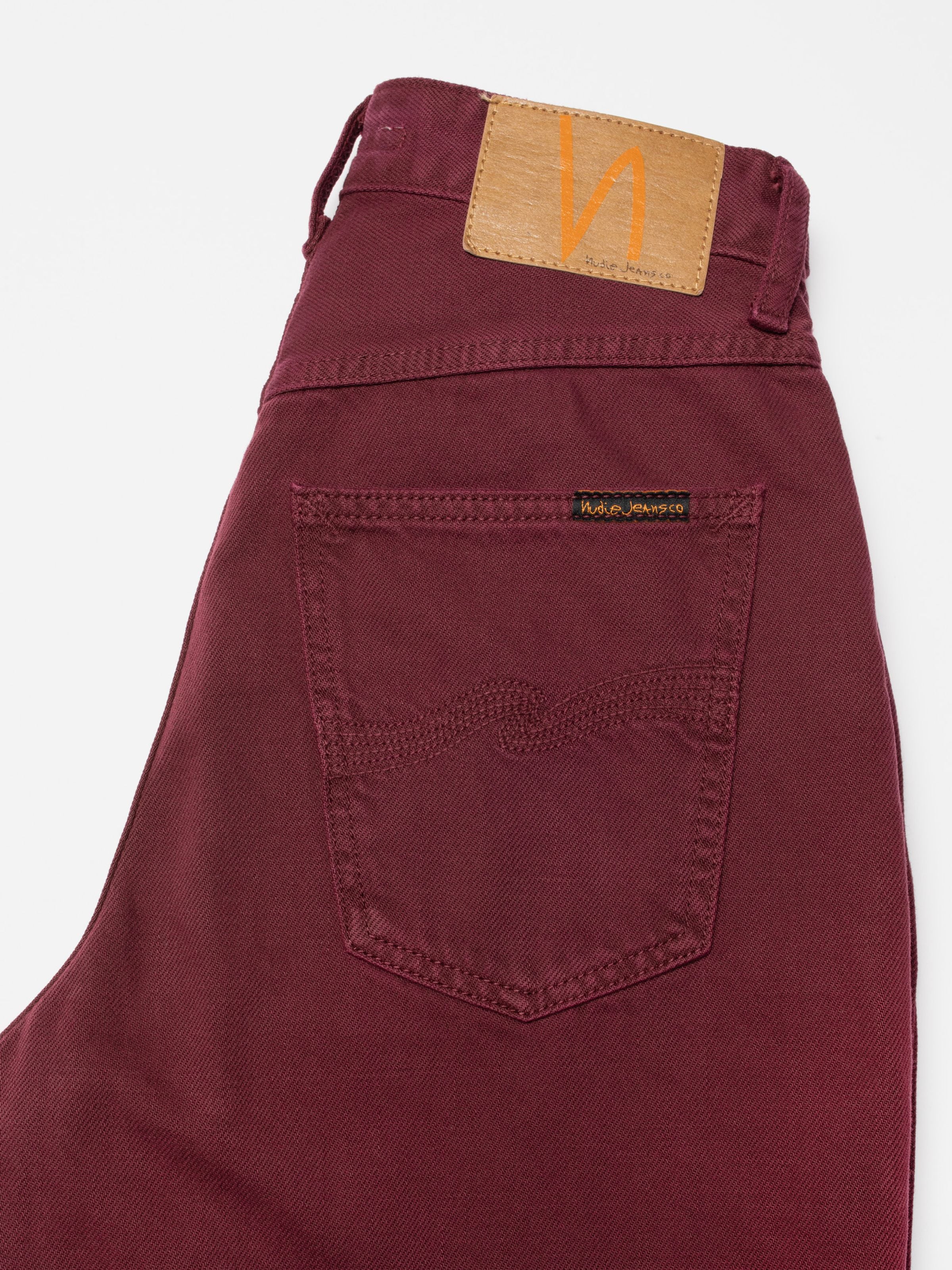 Nudie Jeans Clean Eileen Burgundy, close-up of the back pocket and Jacron patch on rigid organic cotton denim.