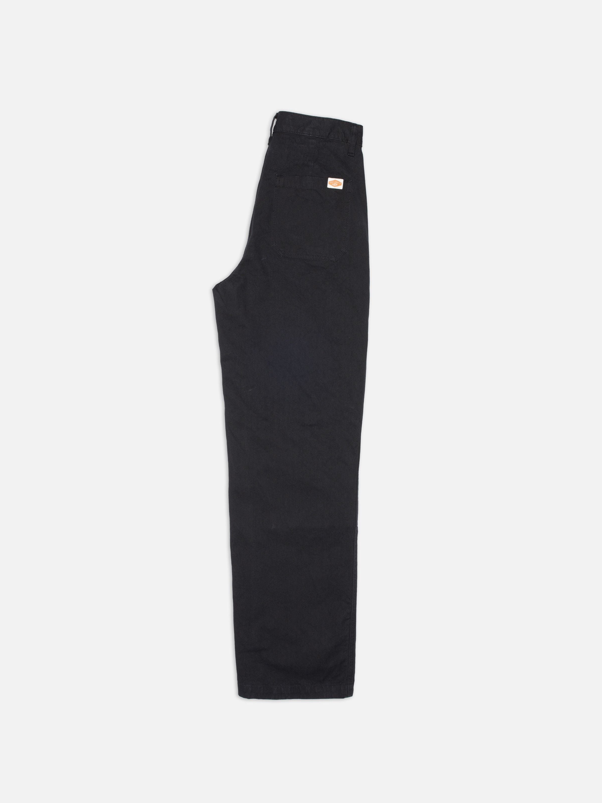Nudie Jeans Wendy Pants Duck Canvas Black, Hose aus Bio-Baumwolle mit weitem Bein, seitlich auf weißem Hintergrund.