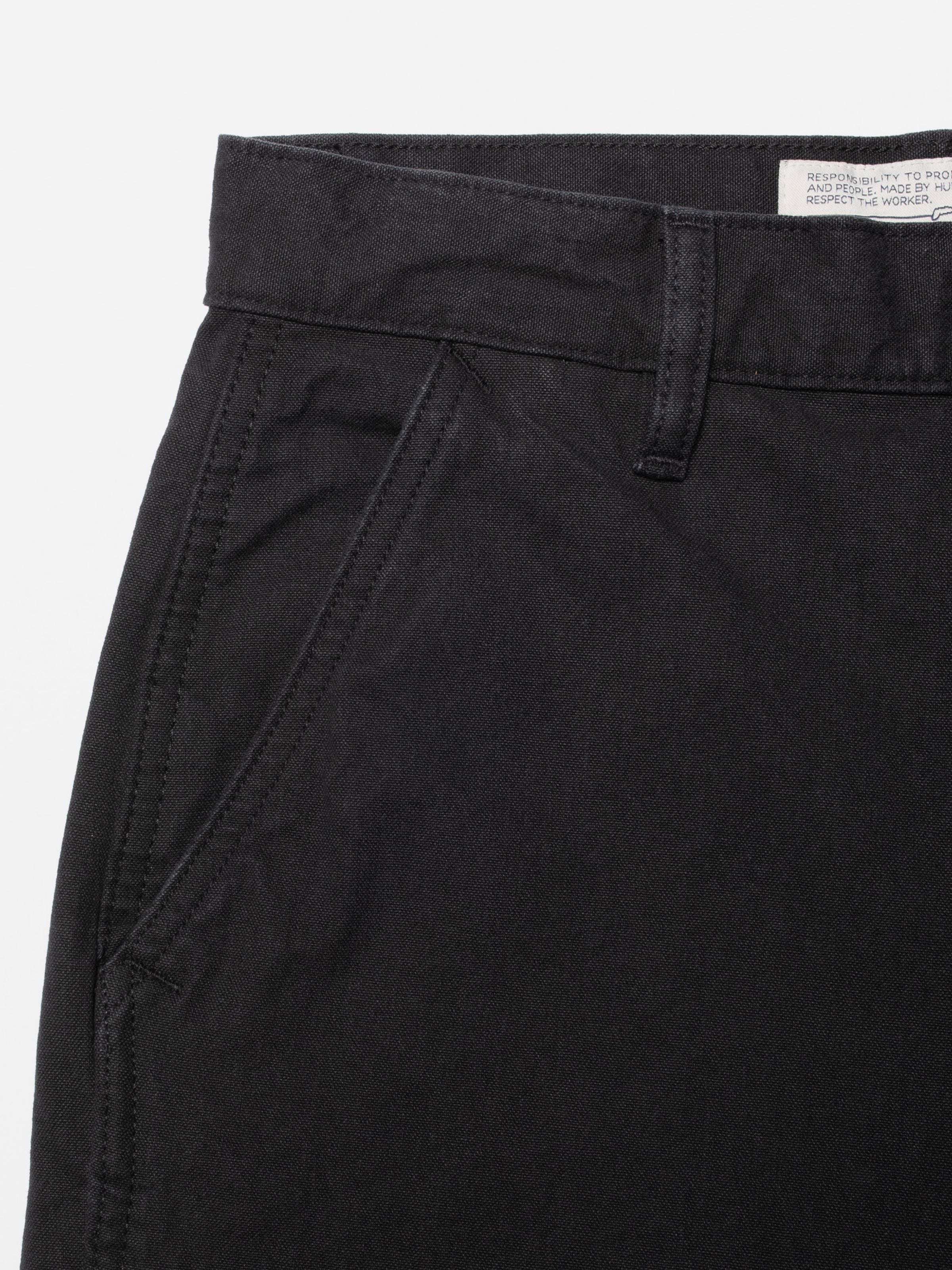 Nudie Jeans Wendy Pants Duck Canvas Black, Nahaufnahme von Vordertasche und Bund aus Duck Canvas aus Bio-Baumwolle.