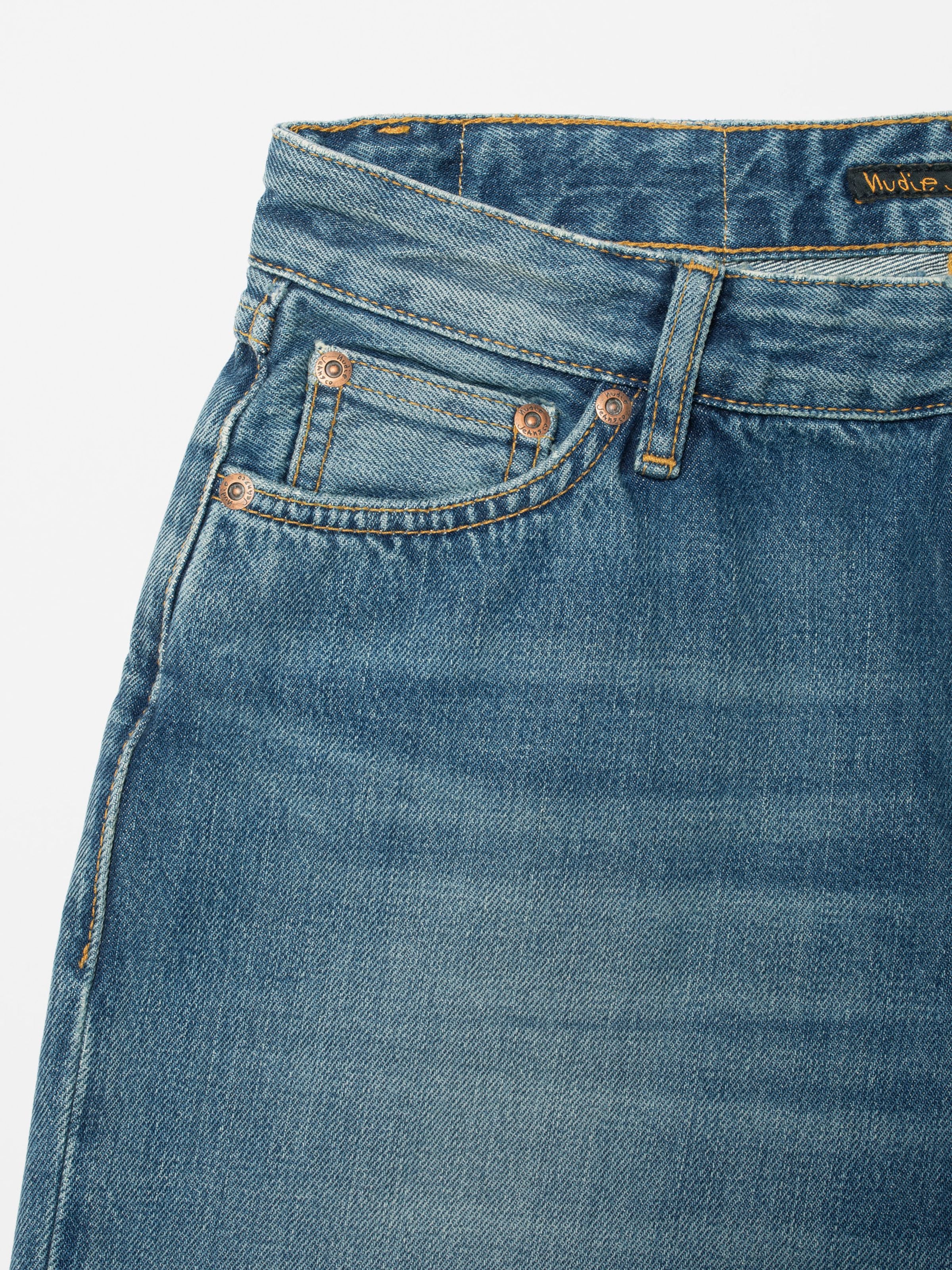 Nudie Jeans Wide Heidi Gravel Stone, close-up of the front pocket and copper rivets on organic cotton rigid denim.
