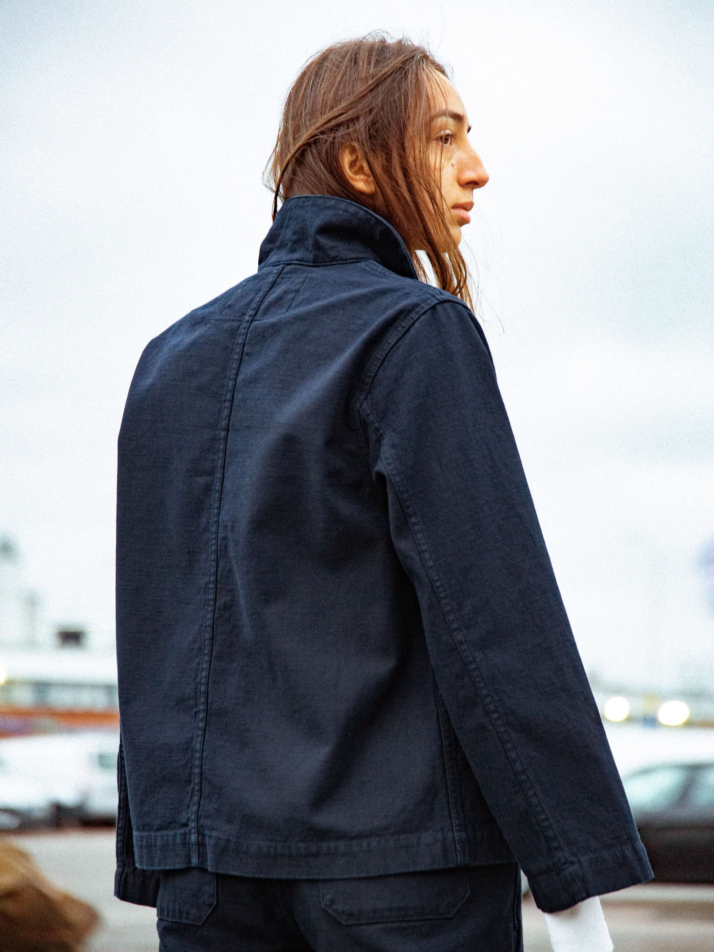 Nudie Jeans Lovis Jacket Back Sateen Indigo, Workwear-Jacke aus Bio-Baumwolle, von hinten an einem Model gezeigt.