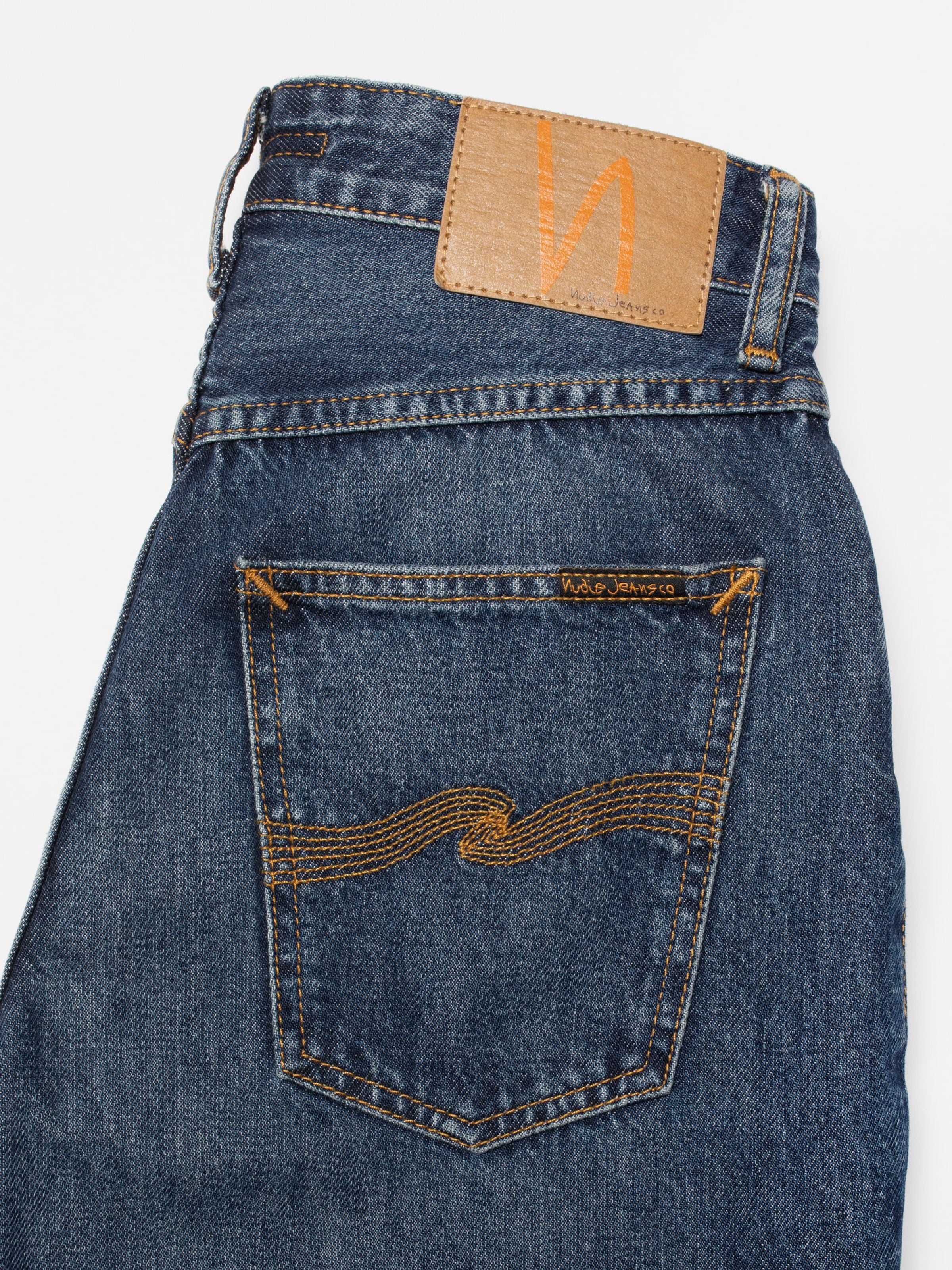 Nudie Jeans Clean Eileen Midnight Rain, close-up of back pocket with orange stitching on blue organic cotton denim.