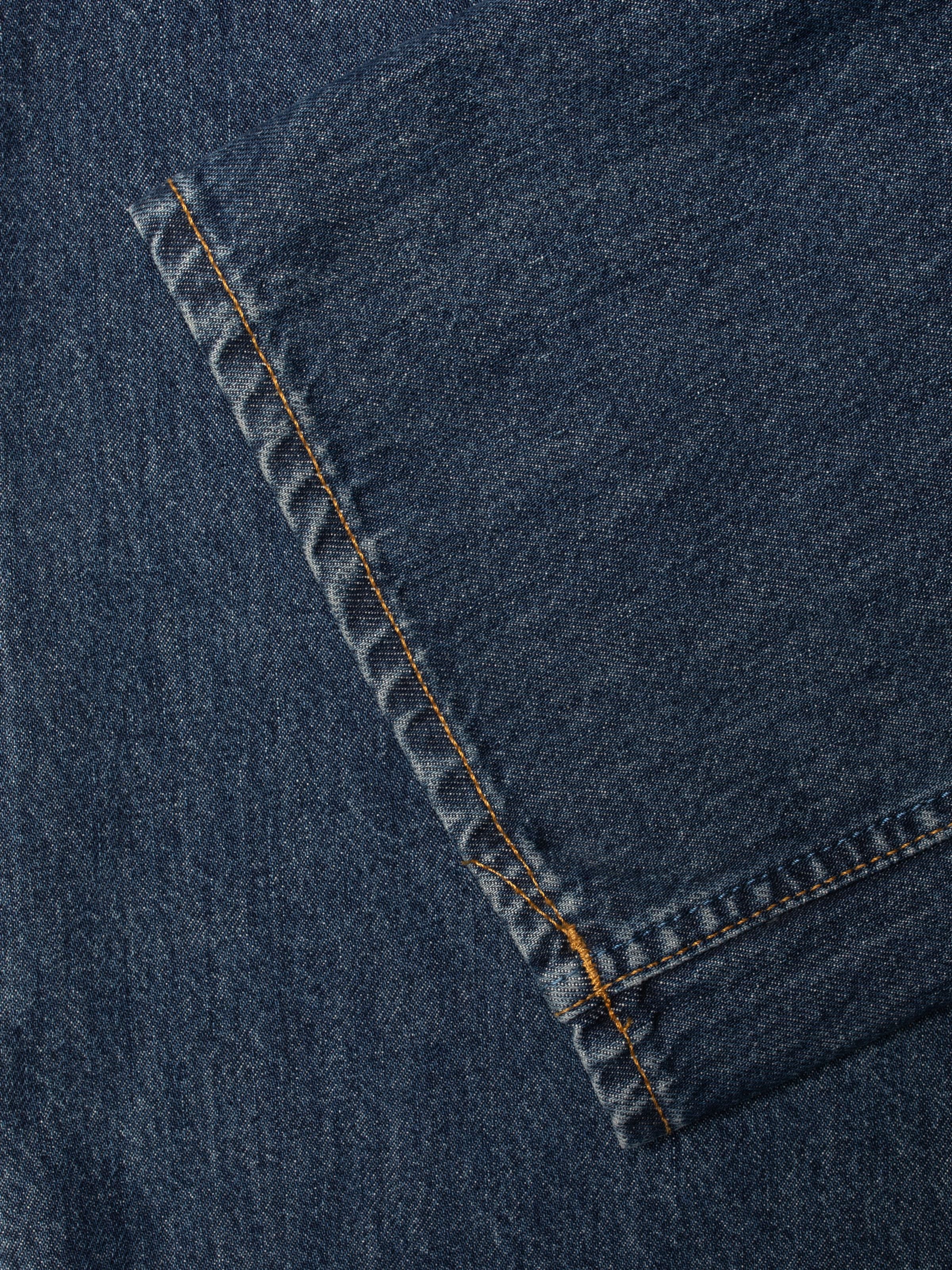 Nudie Jeans Clean Eileen Midnight Rain, close-up of the organic cotton denim showing tobacco-colored stitching.