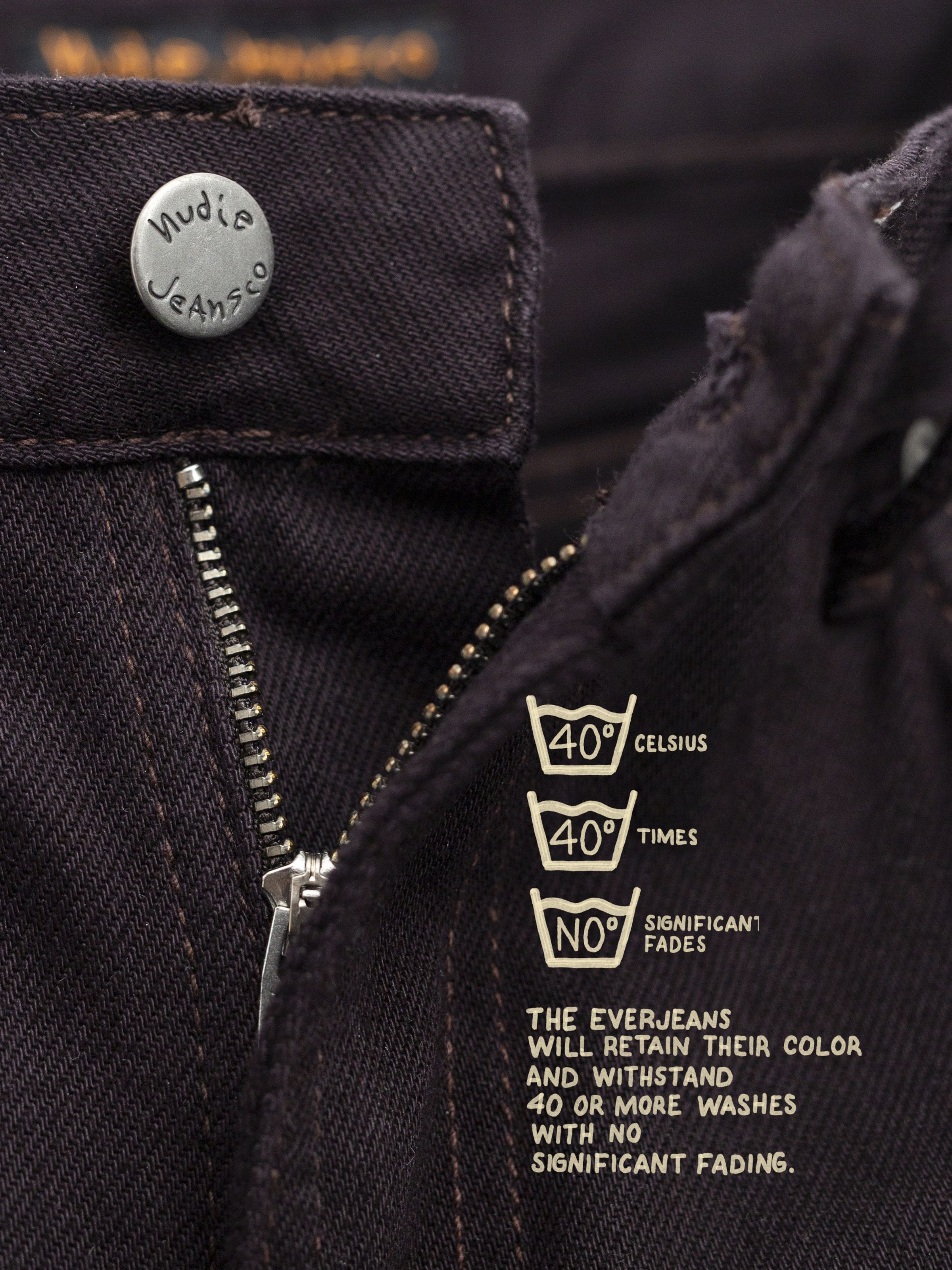 Nudie Jeans Sonic Sue Everbrown, a close-up of the zip fly and antique silver button on deep brown organic cotton denim.