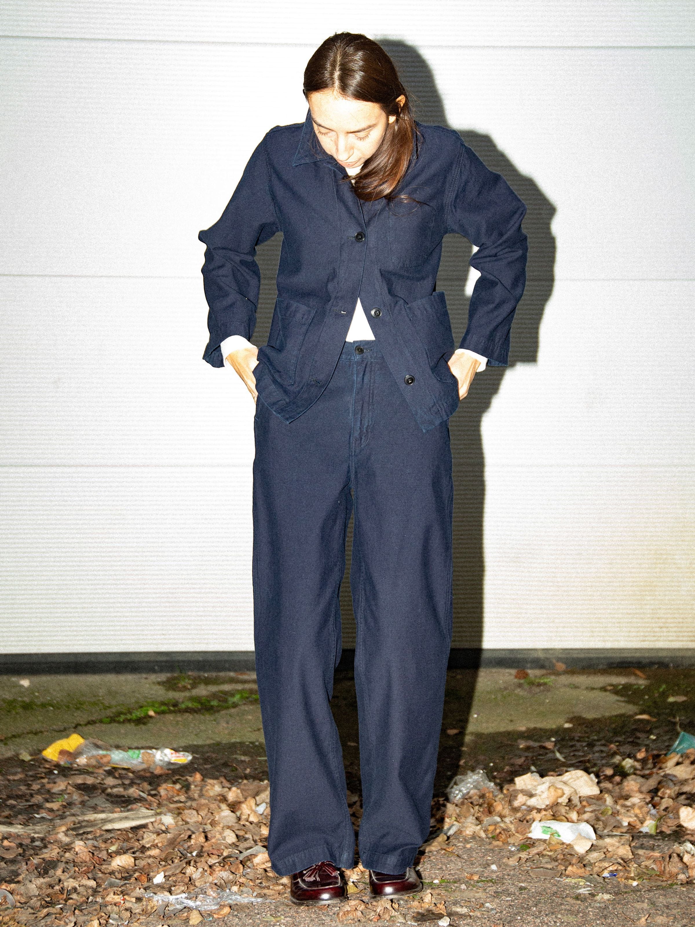 Nudie Jeans Wendy Pants Back Sateen Indigo, Hose mit weitem Bein aus Bio-Baumwolle, an einem Model im Freien gezeigt.