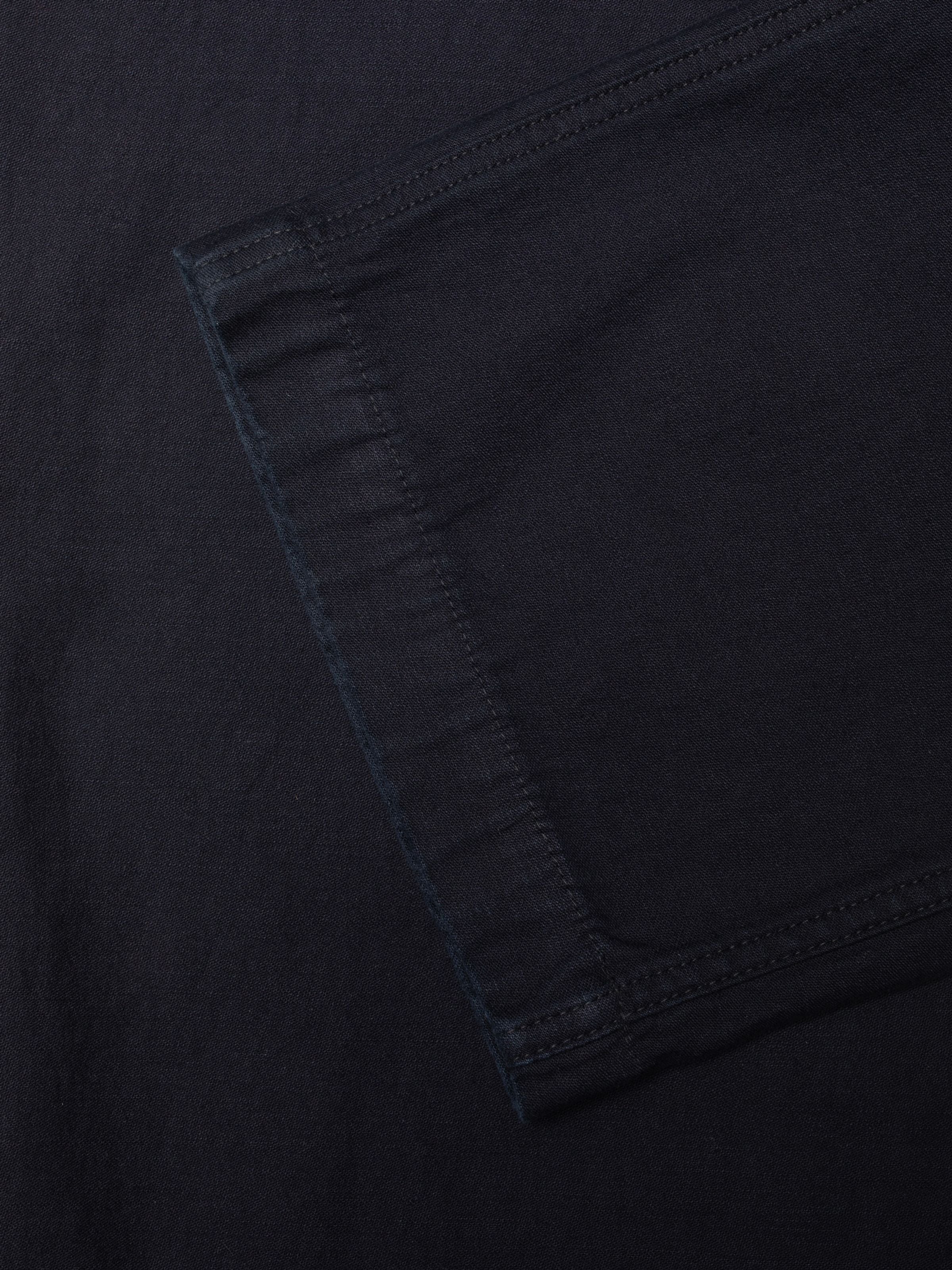 Nudie Jeans Wendy Pants in Indigo, Nahaufnahme des Back Sateen-Gewebes aus Bio-Baumwolle und Taschendetail.