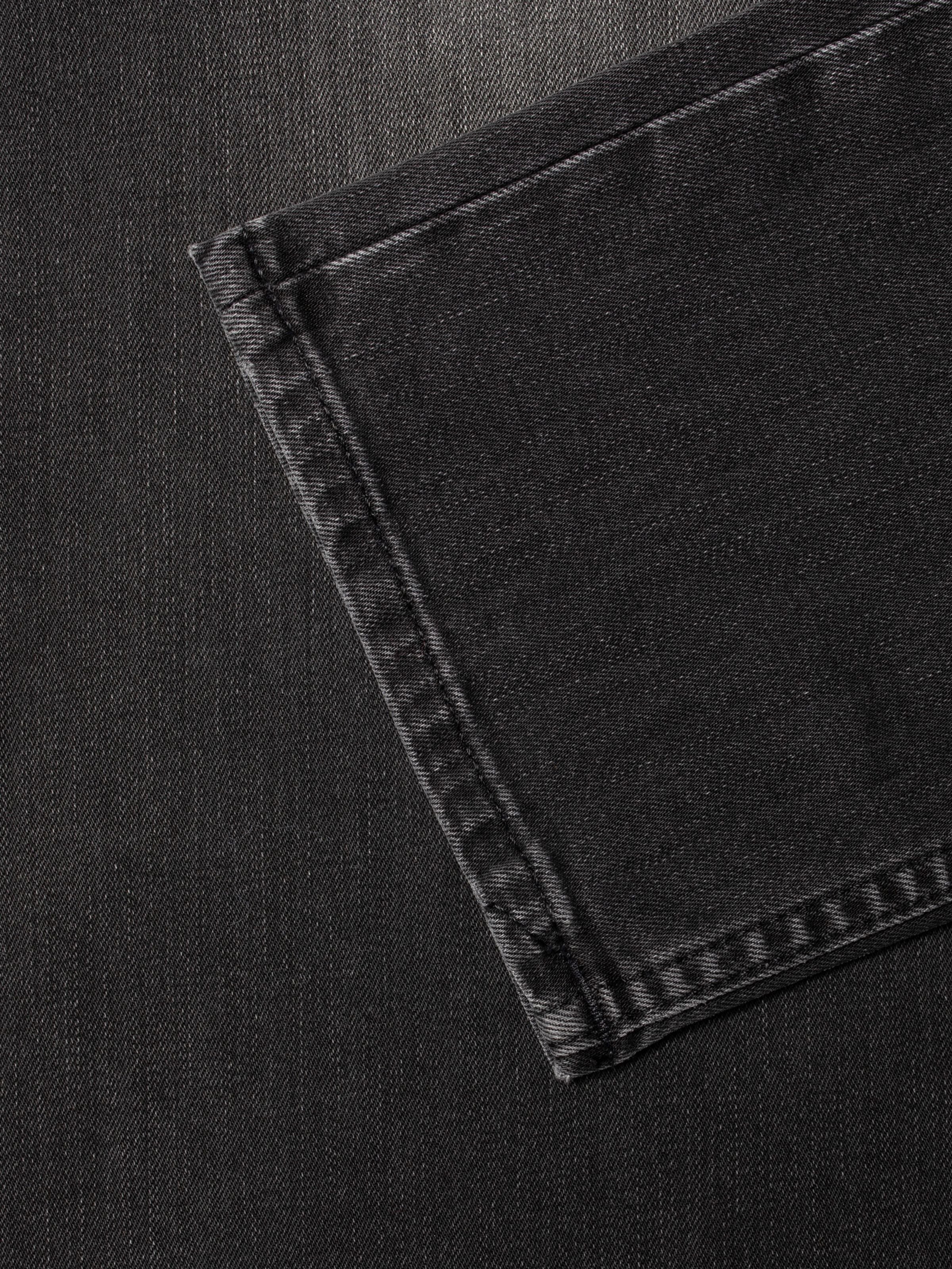 Nudie Jeans Solid Ollie Black Mist, close-up of the leg opening on mid-grey organic cotton comfort stretch denim jeans.