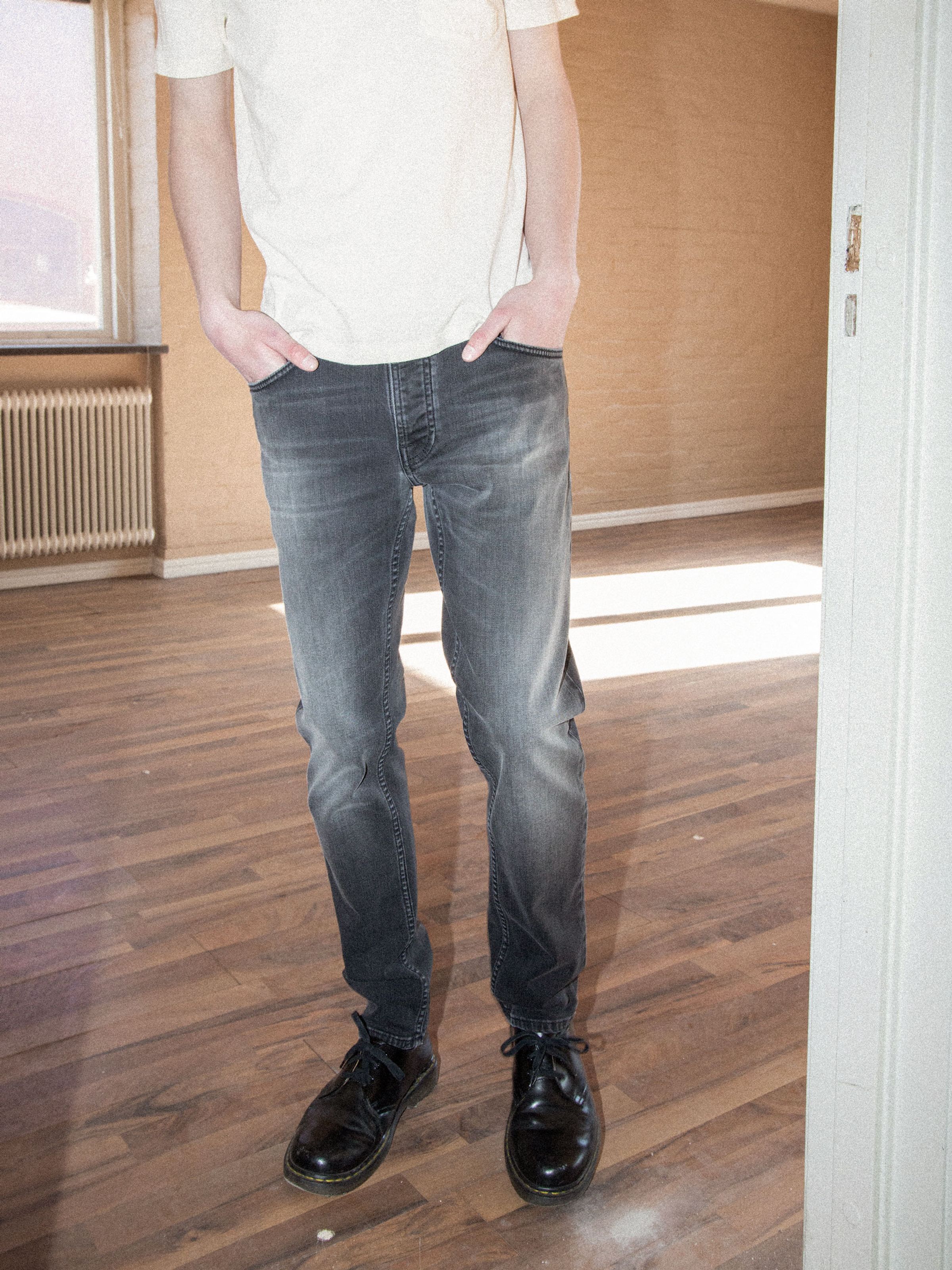 Nudie Jeans Solid Ollie Black Mist, Herrenjeans mit schmaler Passform und geradem Bein, von vorne an einem Model gezeigt.