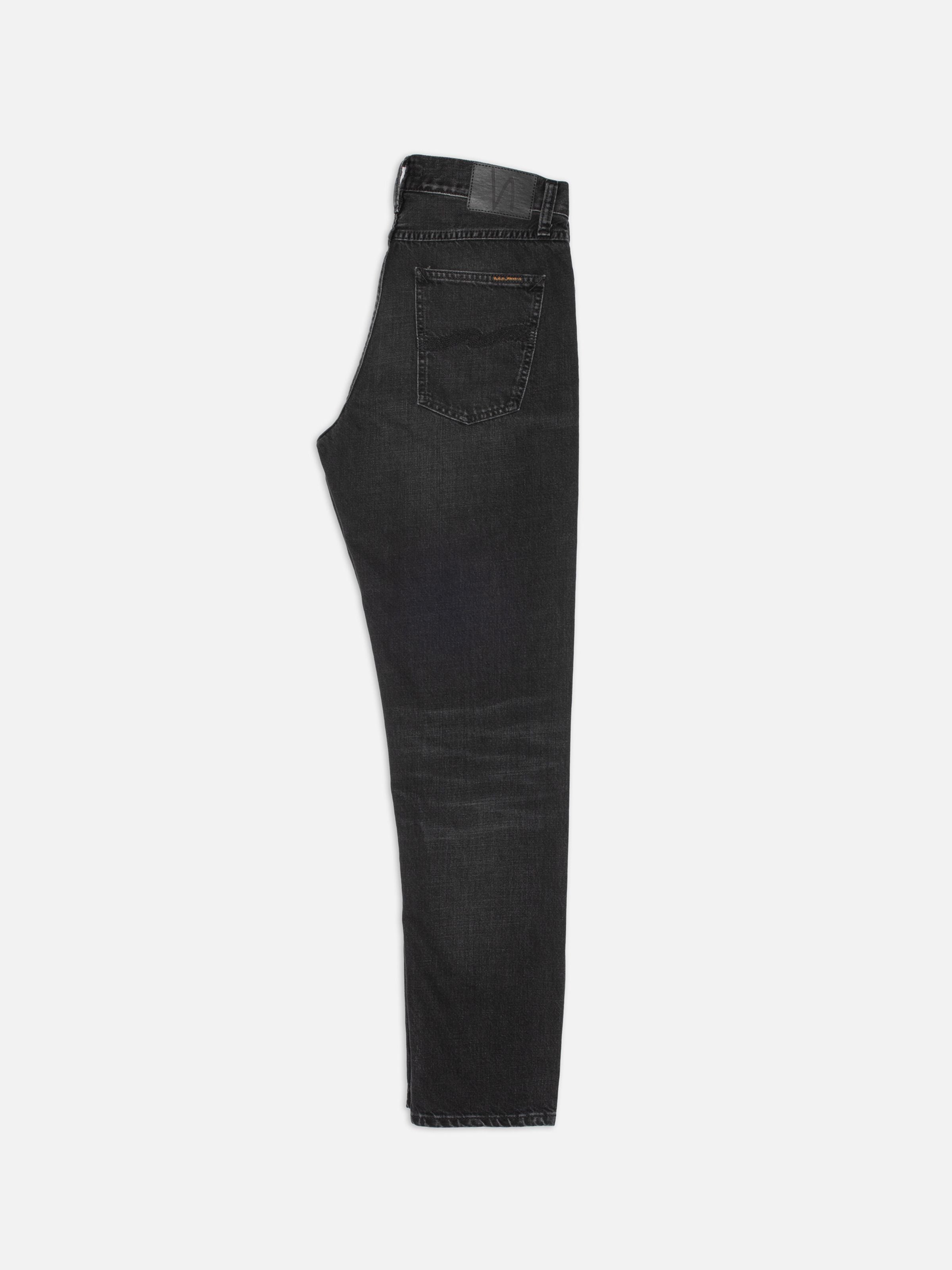 Nudie Jeans Steady Eddie II Black Fog, reguläre Tapered Jeans, Seitenansicht mit Gesäßtasche und schwarzem Jacron-Patch.