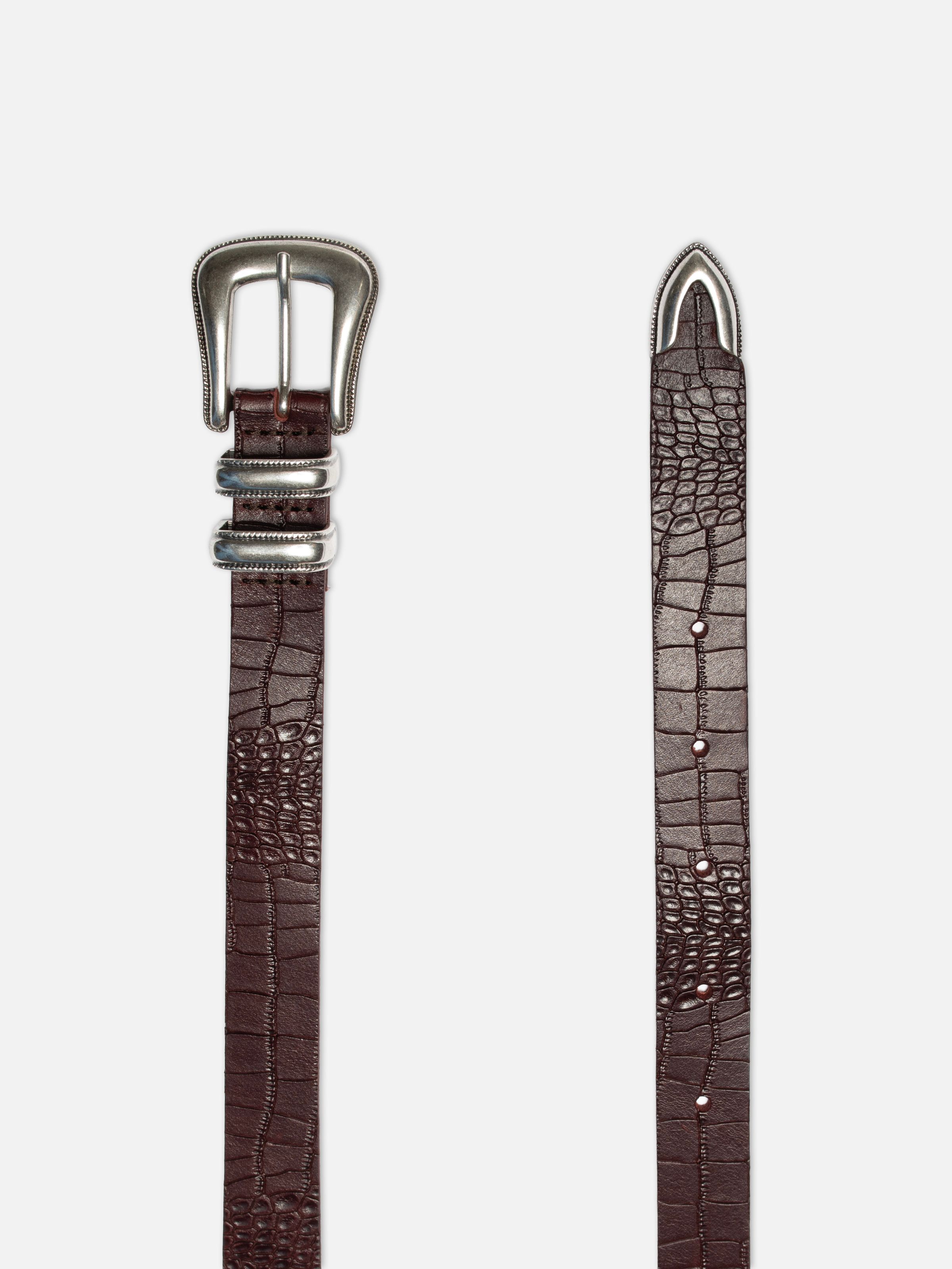 Nudie Jeans Western Faux Croco Silver Belt in Burgundy, showing the ornate silver buckle, tail tip, and embossed leather.