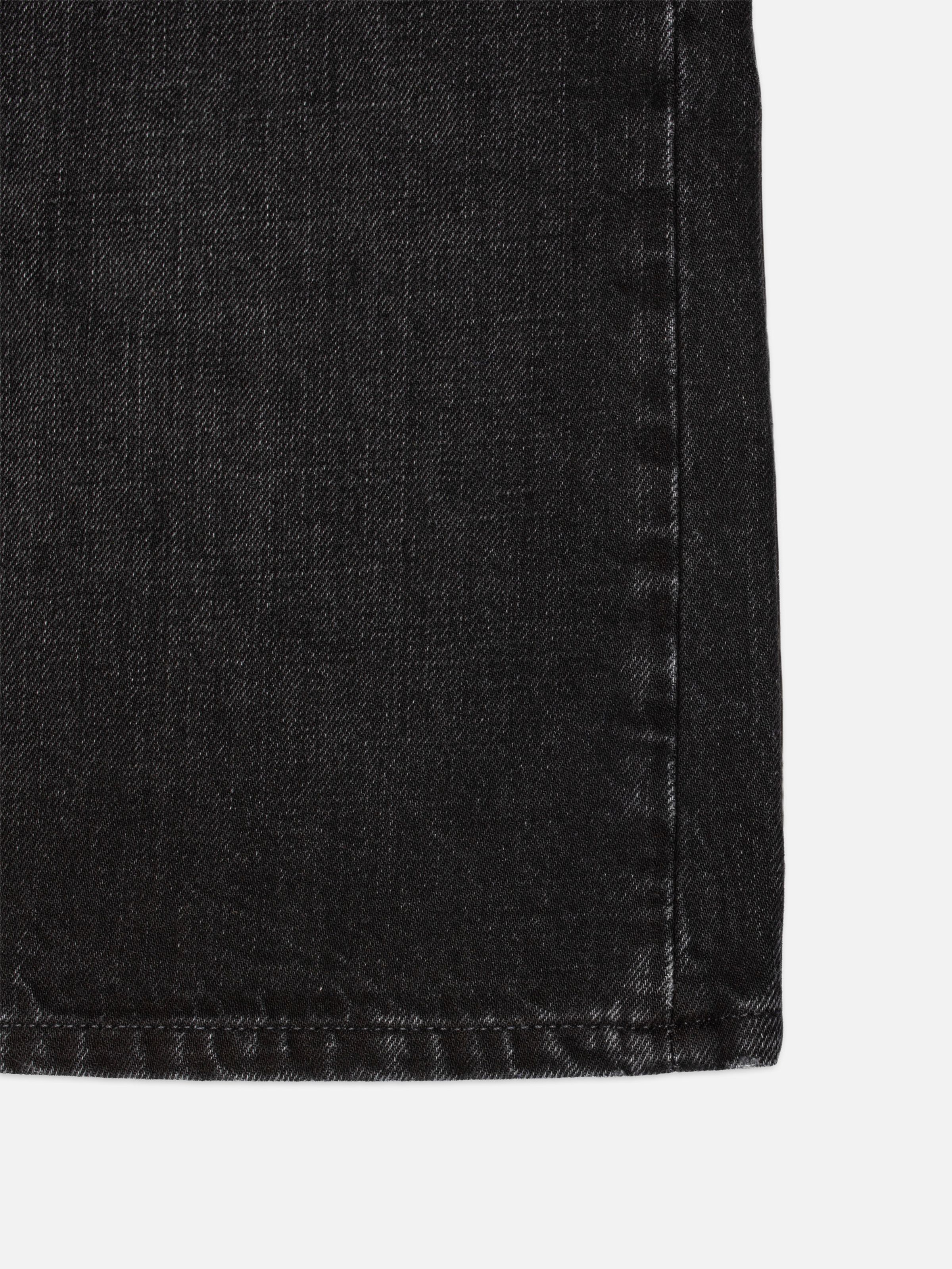 Nudie Jeans Zeb Denim Shorts Night Dune, close-up of the black denim fabric showing the slub and marbling textures.