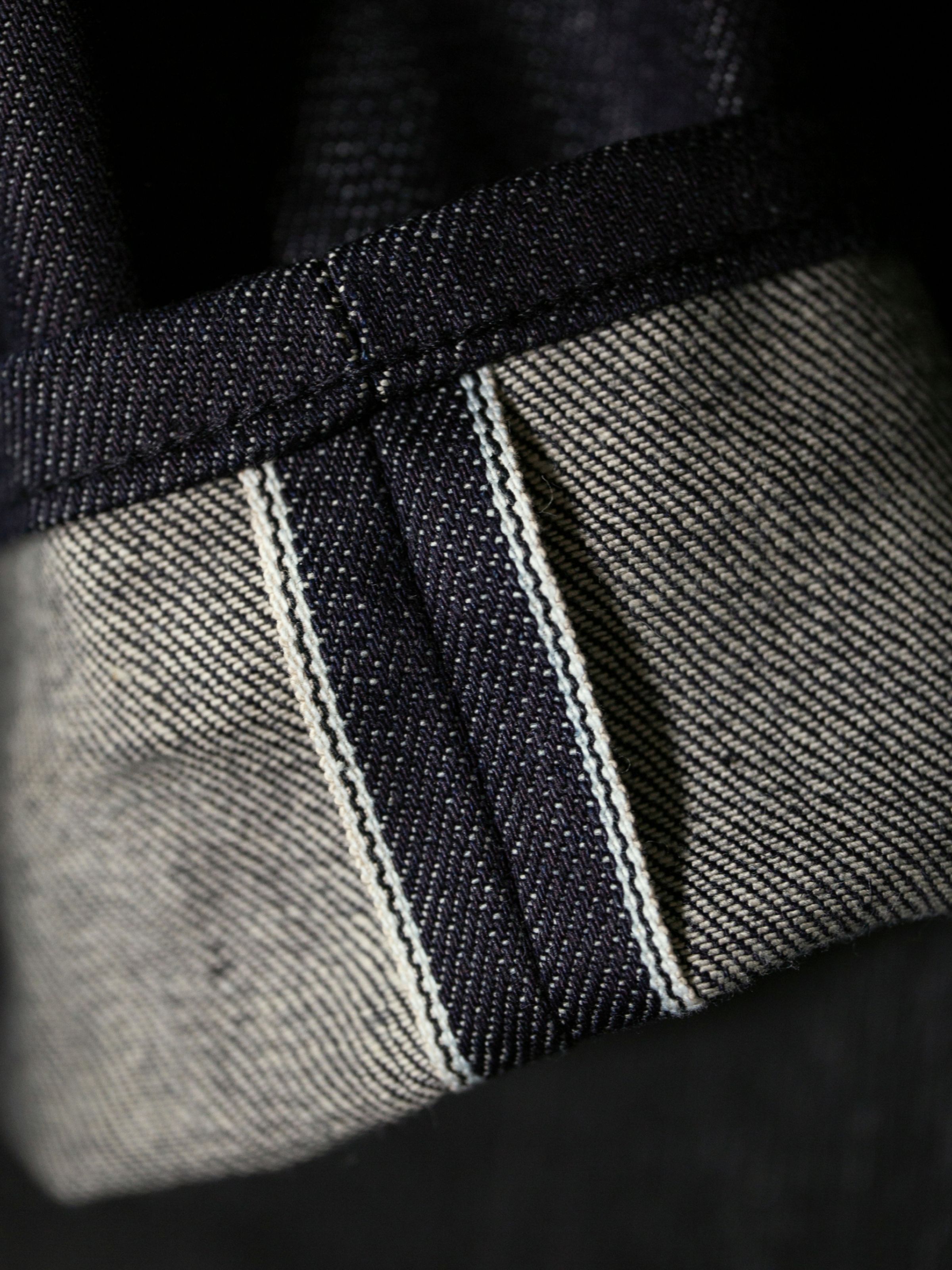 Nudie Jeans Solid Ollie Dry Eclipse Selvage, a close-up detail of the turned-up cuff showing the white selvedge ID.