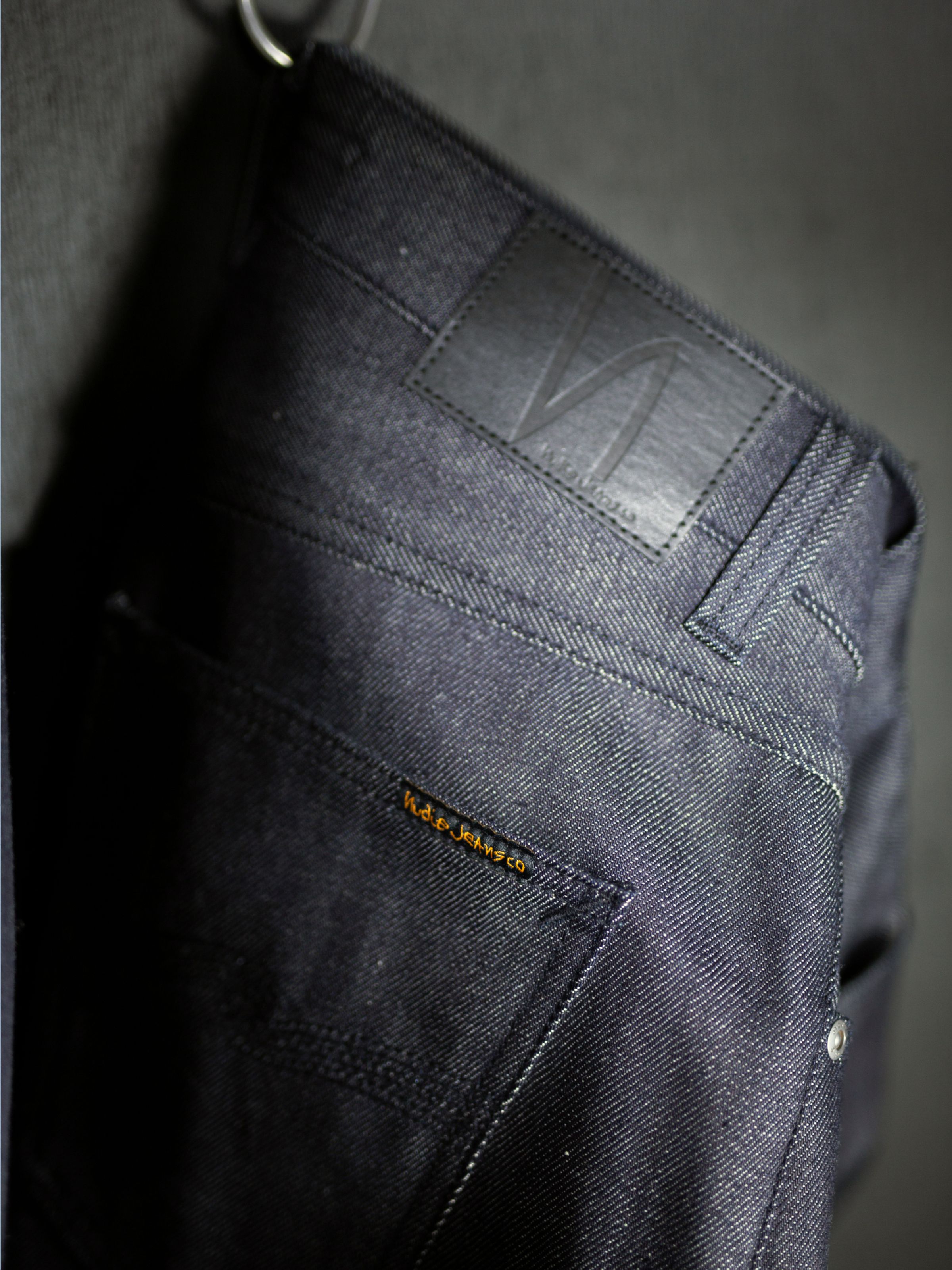 Nudie Jeans Solid Ollie Dry Eclipse Selvage, men's slim straight jeans, showing a back pocket and jacron patch detail.
