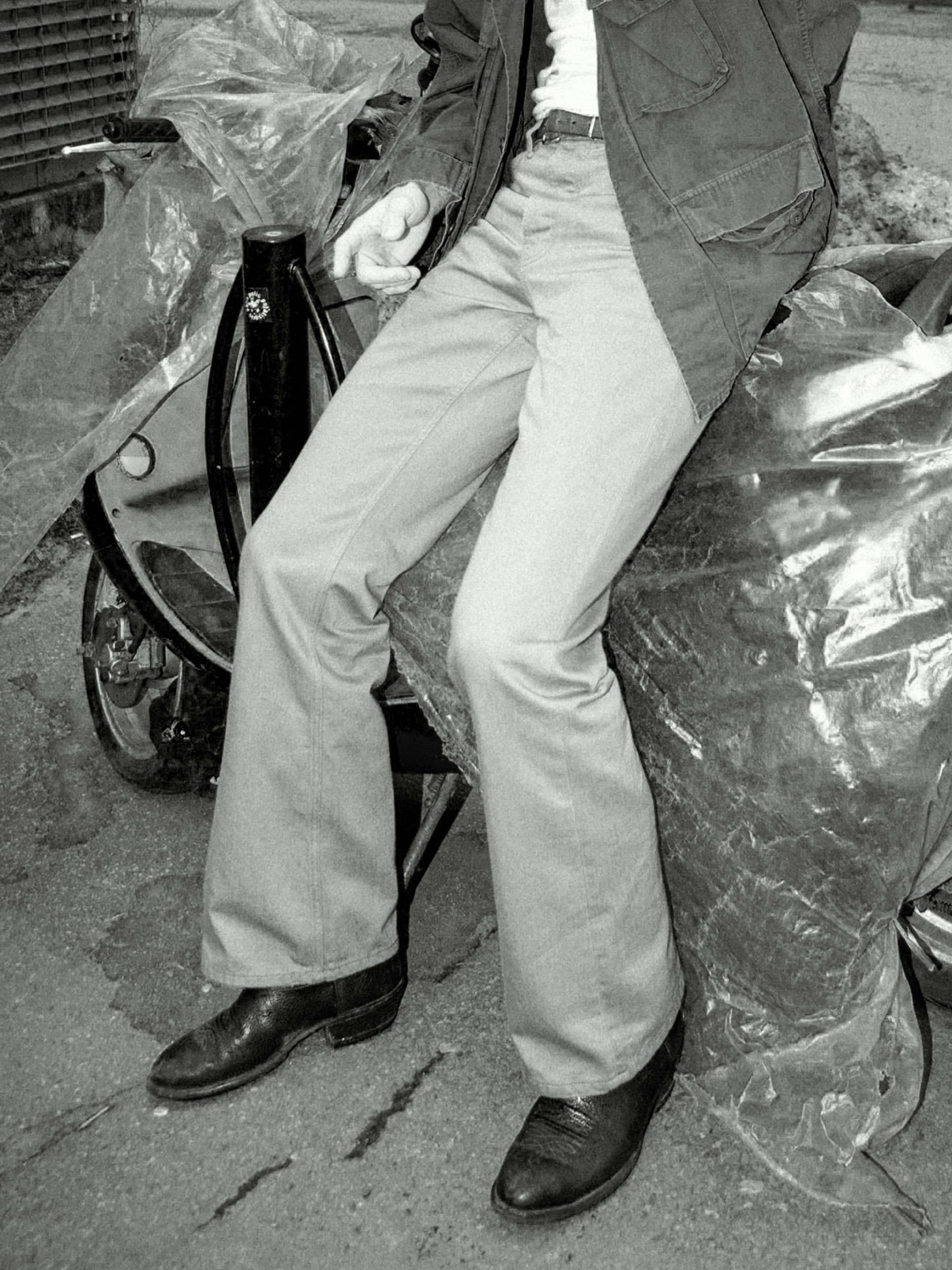 Nudie Jeans Flare Glenn Everlion, men's flared leg jeans, shown on a model sitting down.