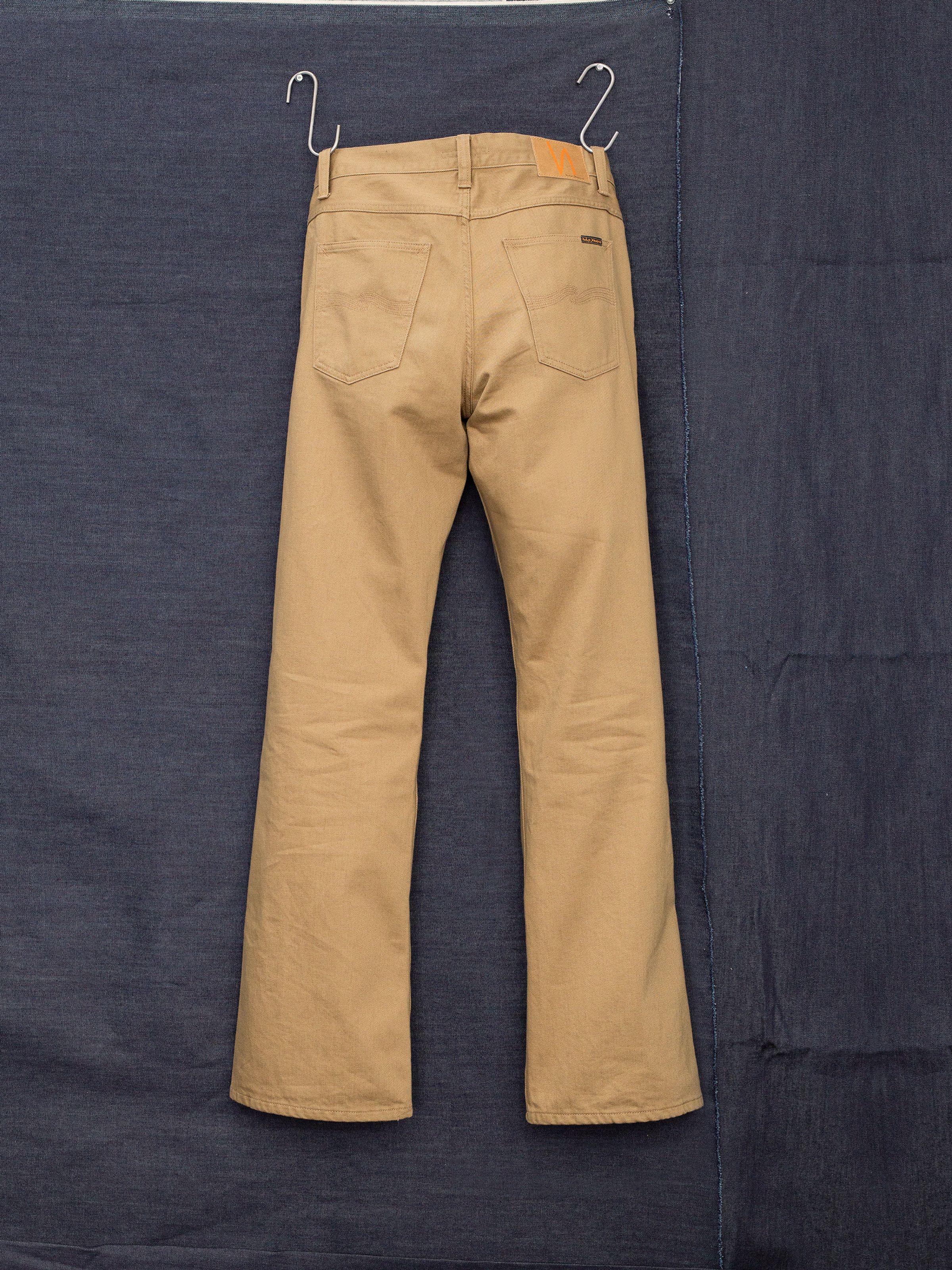 Nudie Jeans Flare Glenn Everlion, men's tobacco-colored flared jeans, shown from the back hanging against a blue backdrop.