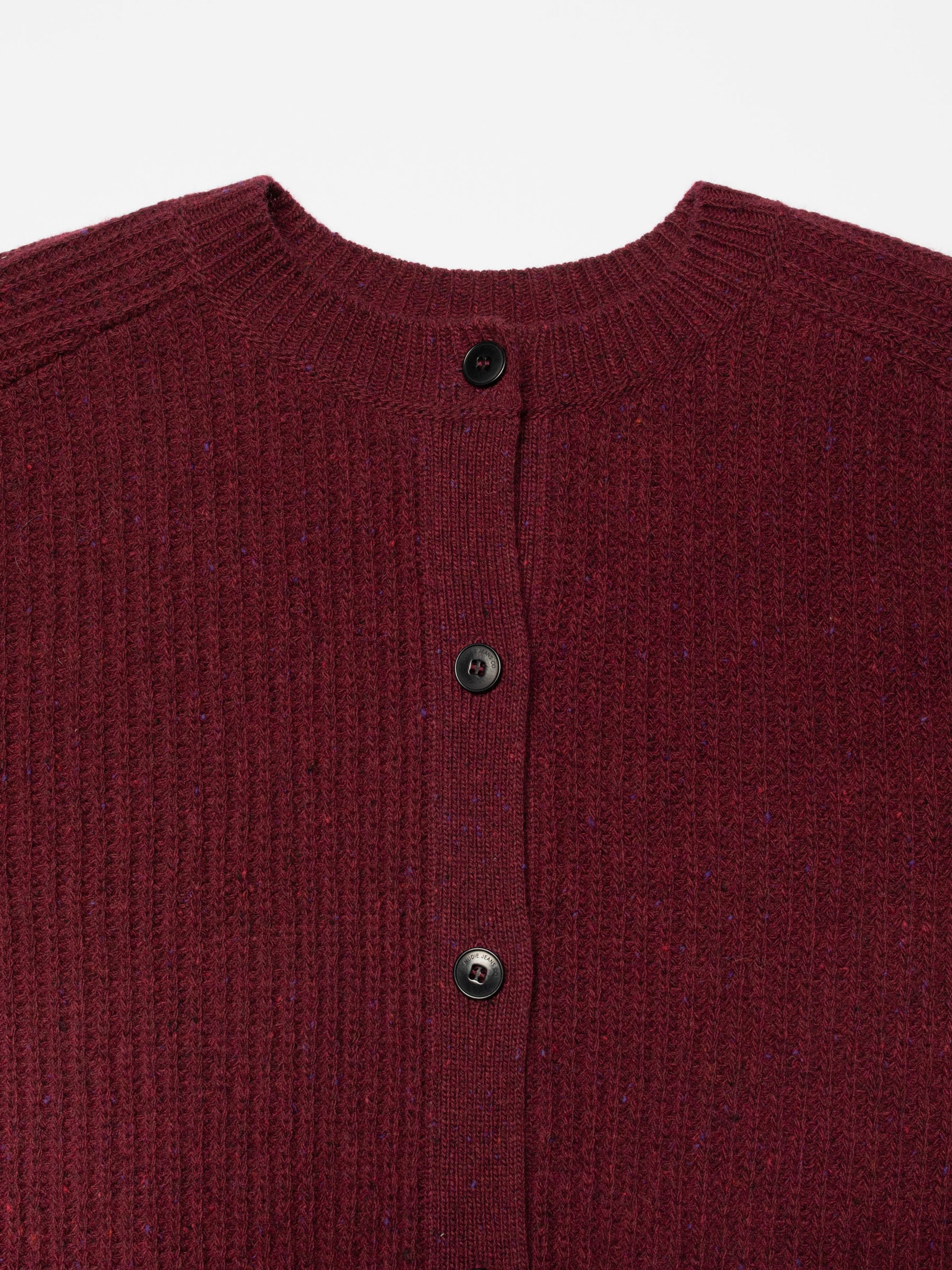 Nudie Jeans Ellen Cardigan Wool in Burgundy, Nahaufnahme des Bio-Wollstricks mit Neps und Steinnussknöpfen.