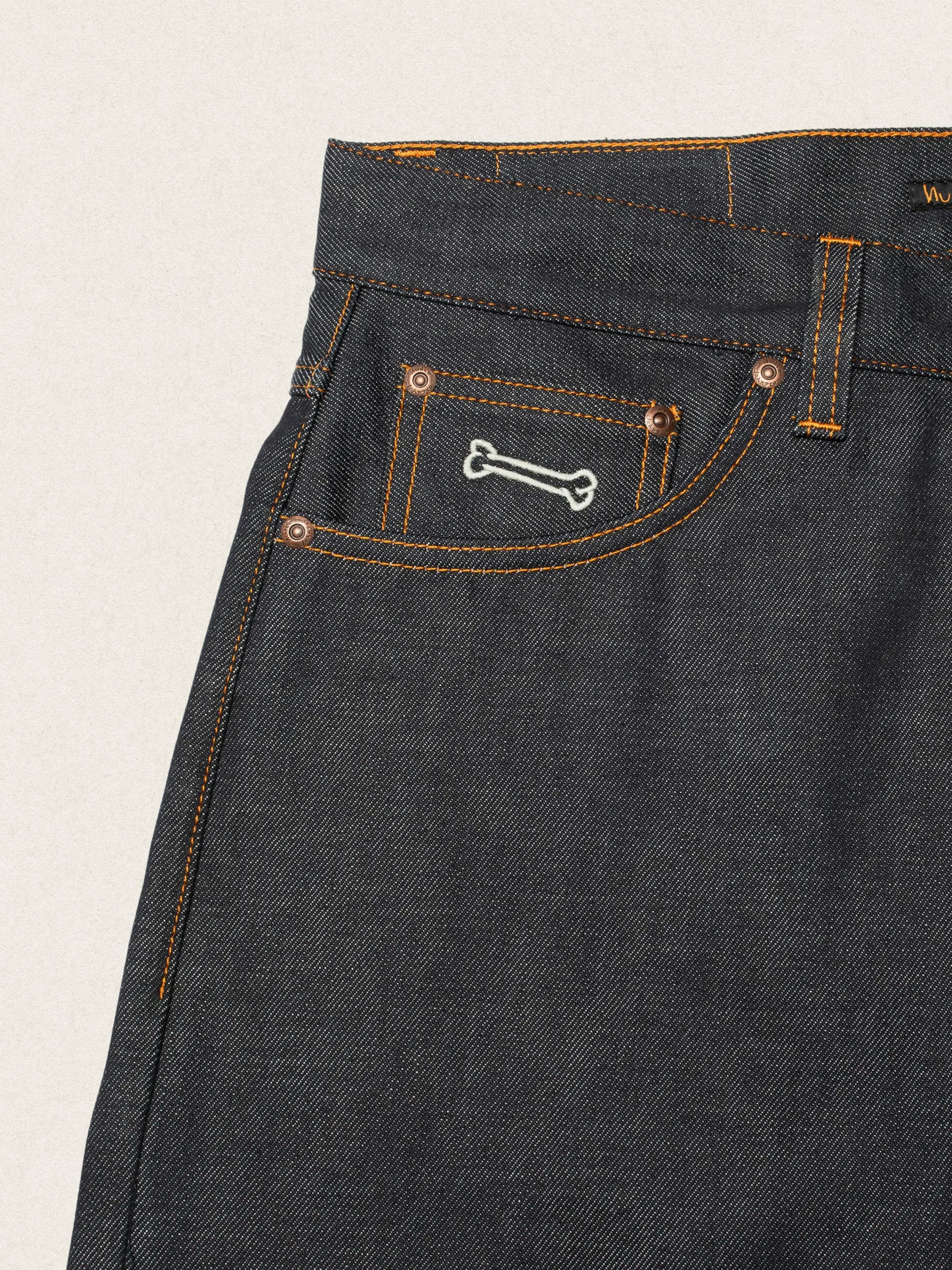 Nudie Jeans Loud Larry Deadstock 25, men's loose fit jeans, close-up of the coin pocket showing the dog bone embroidery.