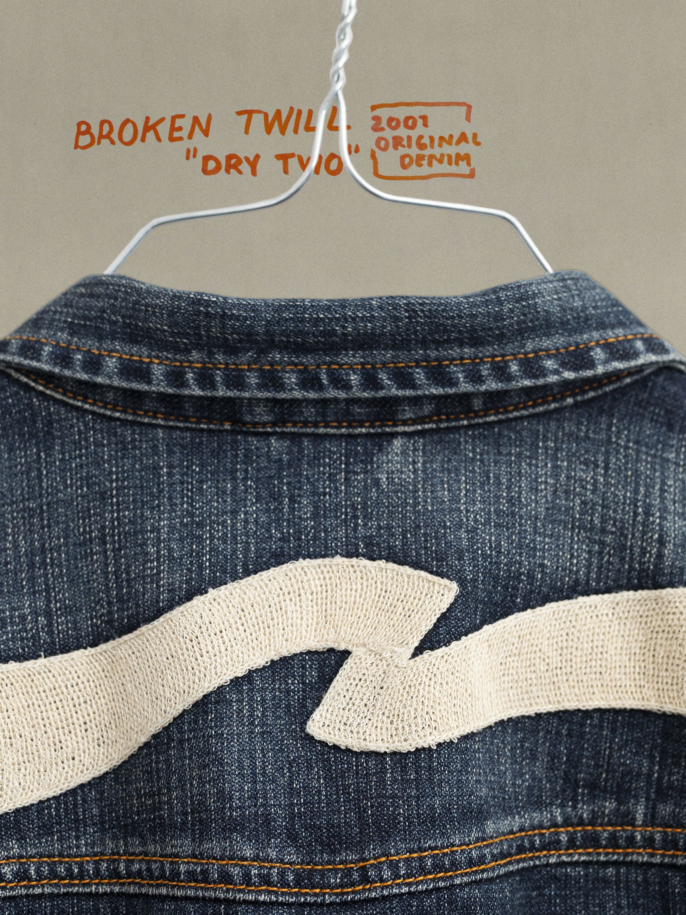 Nudie Jeans Conny Jeansjacke Big Wave mit markanter Ecru-Stickerei auf blauem Rigid Denim aus Bio-Baumwolle.