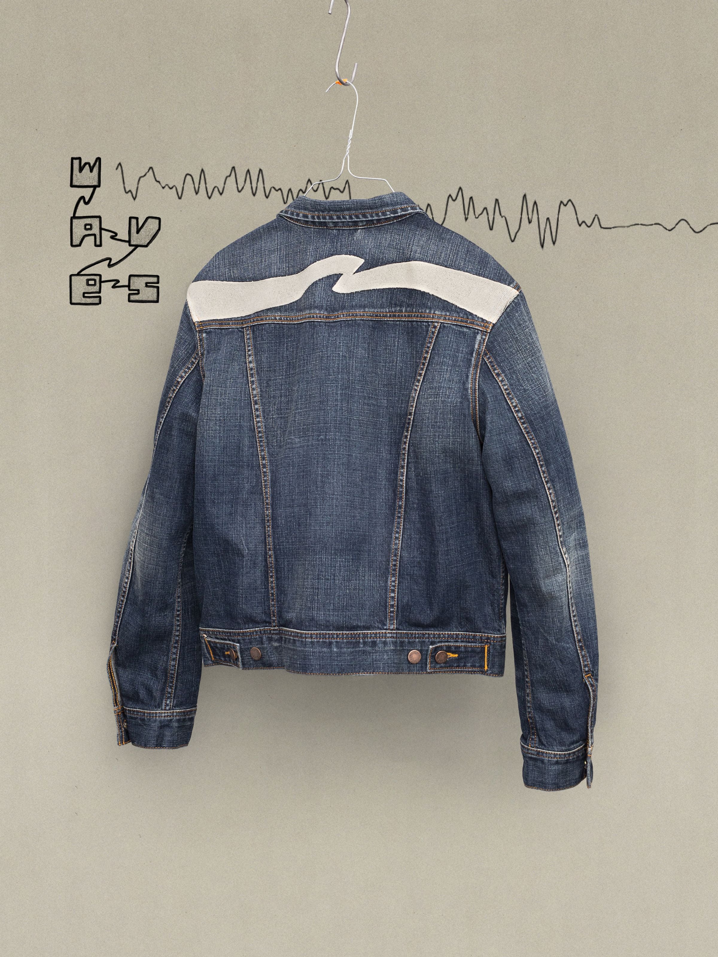 Nudie Jeans Conny Denim Jacket Big Wave, blaue Jeansjacke aus Bio-Baumwolle mit weißer Wellenbestickung auf der Rückenpasse.