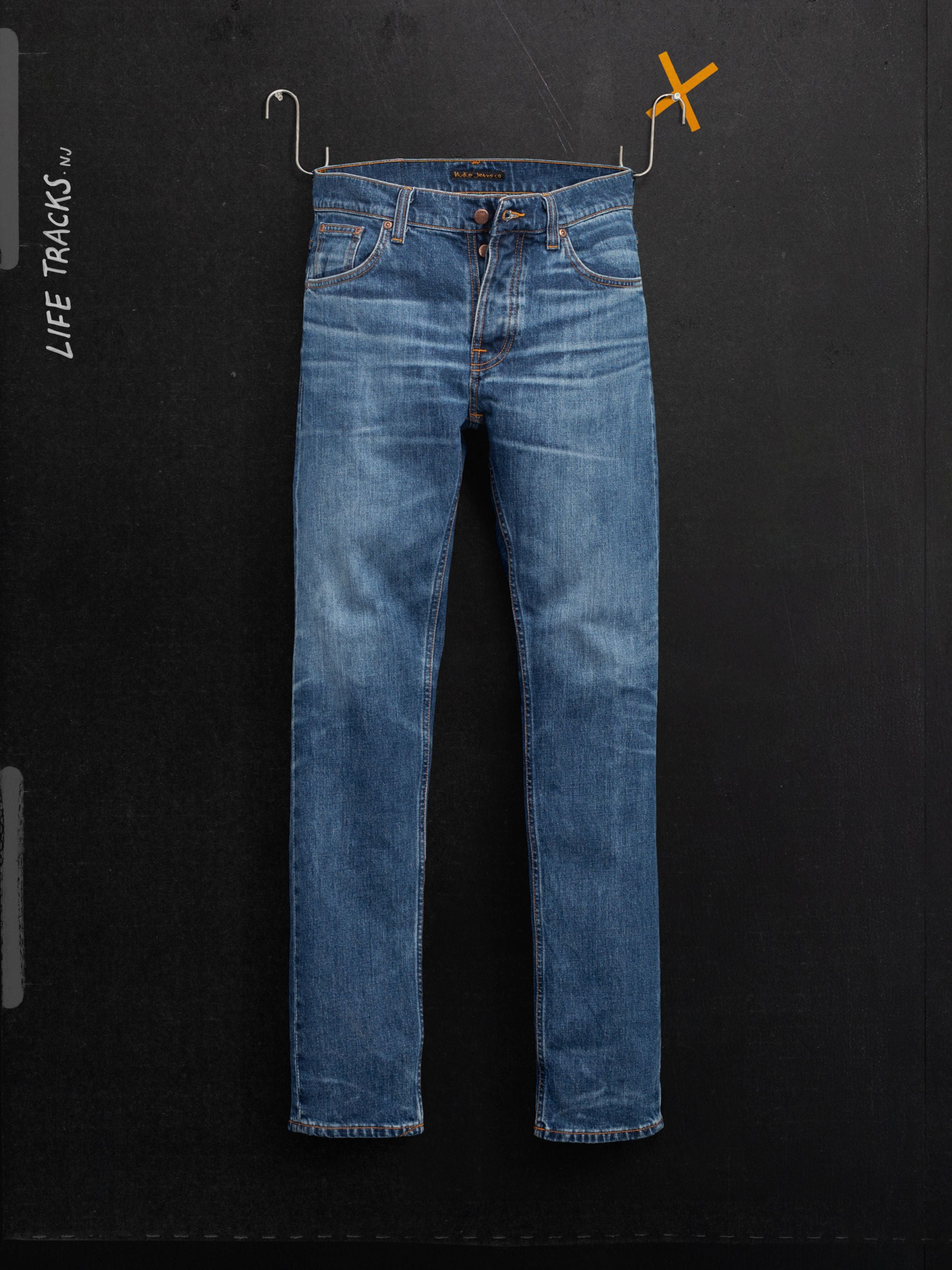 Nudie Jeans Grim Tim Life Tracks slim fit organic cotton jeans in mid blue wash with authentic fades, shown laid flat.