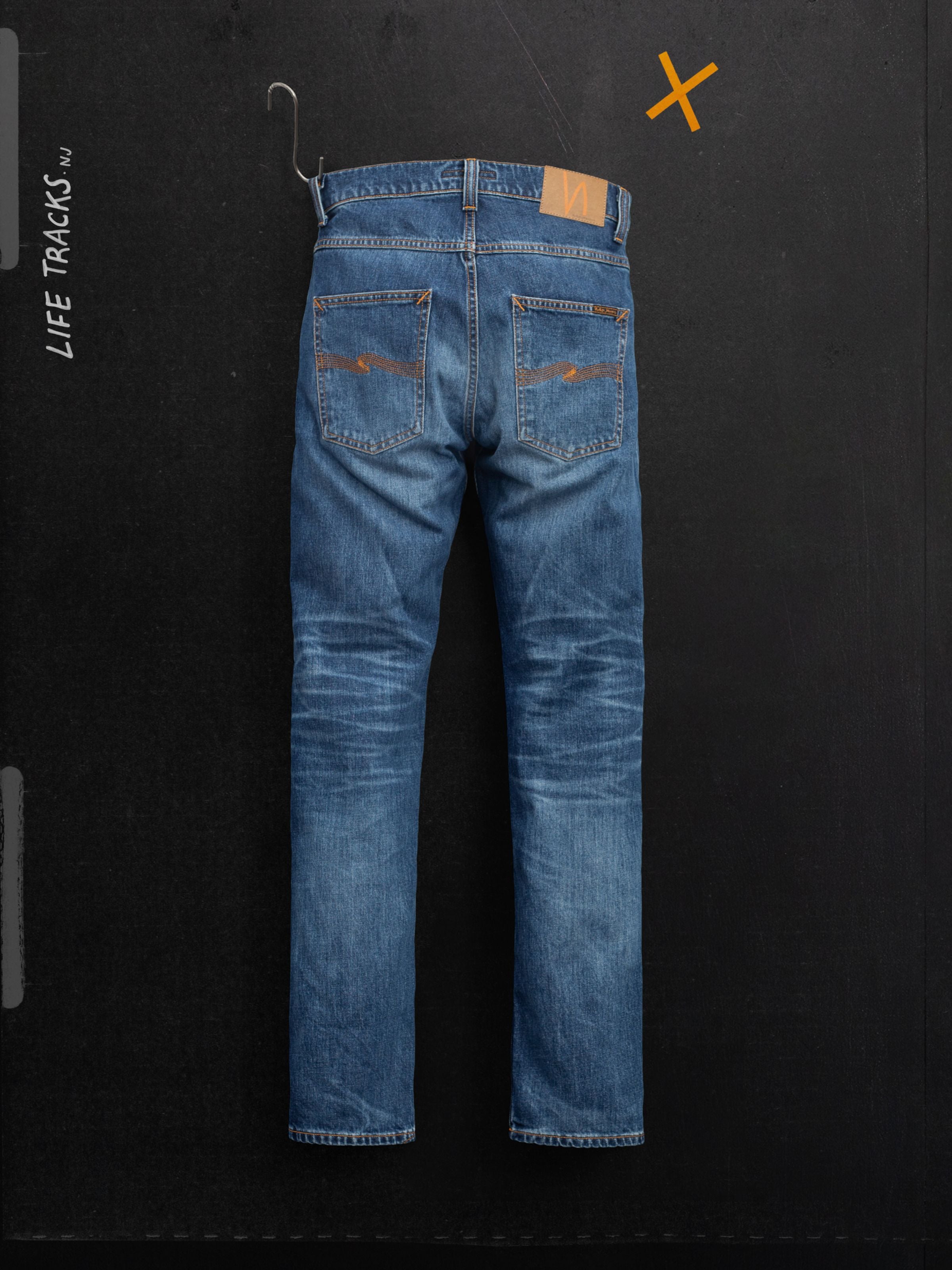 Nudie Jeans Grim Tim Life Tracks, slim fit organic cotton jeans in mid blue wash, back view showing the honeycomb fades.