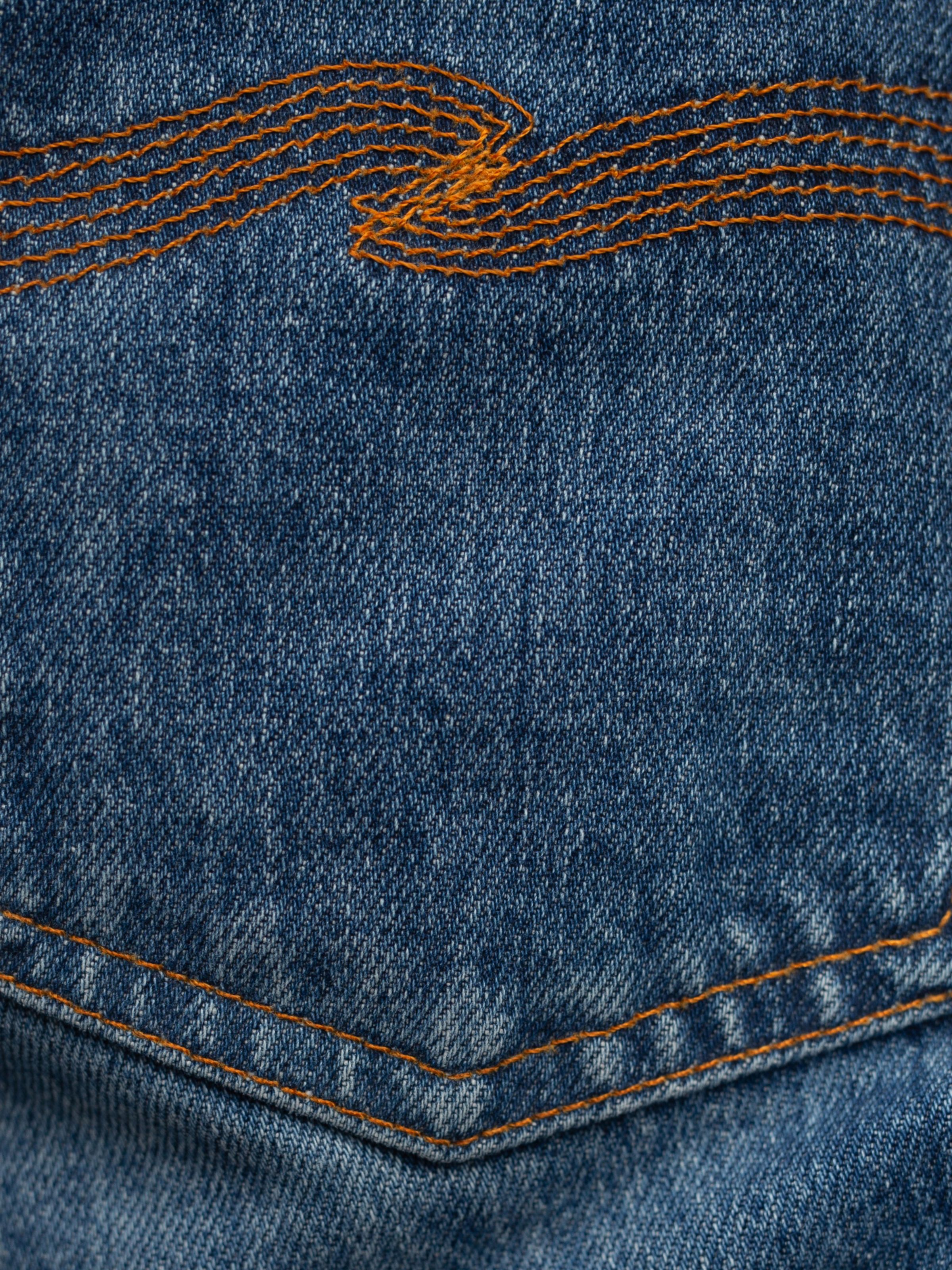 Nudie Jeans Grim Tim Life Tracks, detailed view of organic cotton denim with signature orange back pocket embroidery.