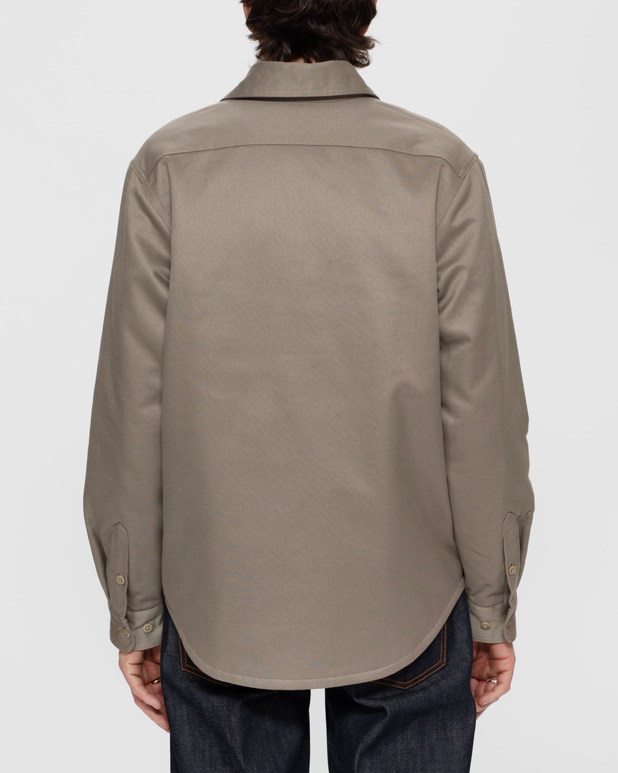 Nudie Jeans Glenn Padded Shirt in Mud, a regular fit overshirt in organic cotton twill, seen from the back.