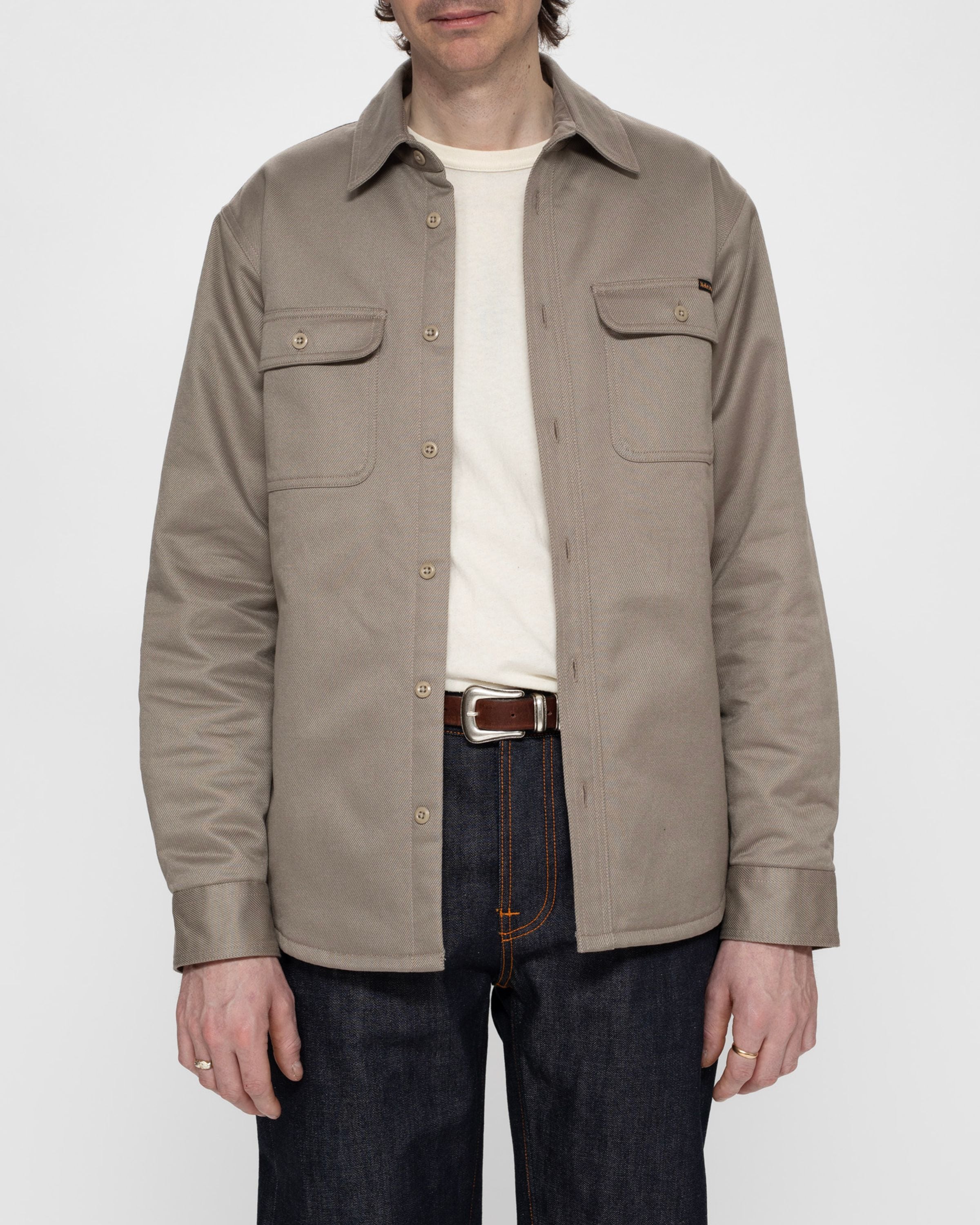 Nudie Jeans Glenn Padded Shirt in Mud, a men's regular fit organic cotton twill overshirt worn by a model.