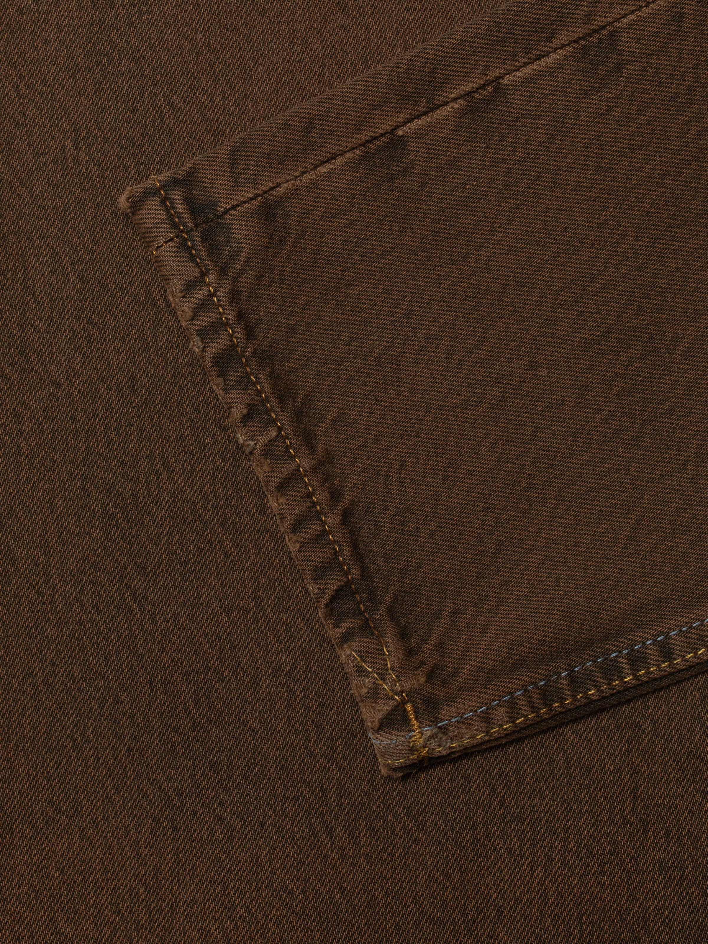Nudie Jeans Steady Eddie II Espresso Lagha, close-up detail of the overdyed brown rigid denim and stitching.