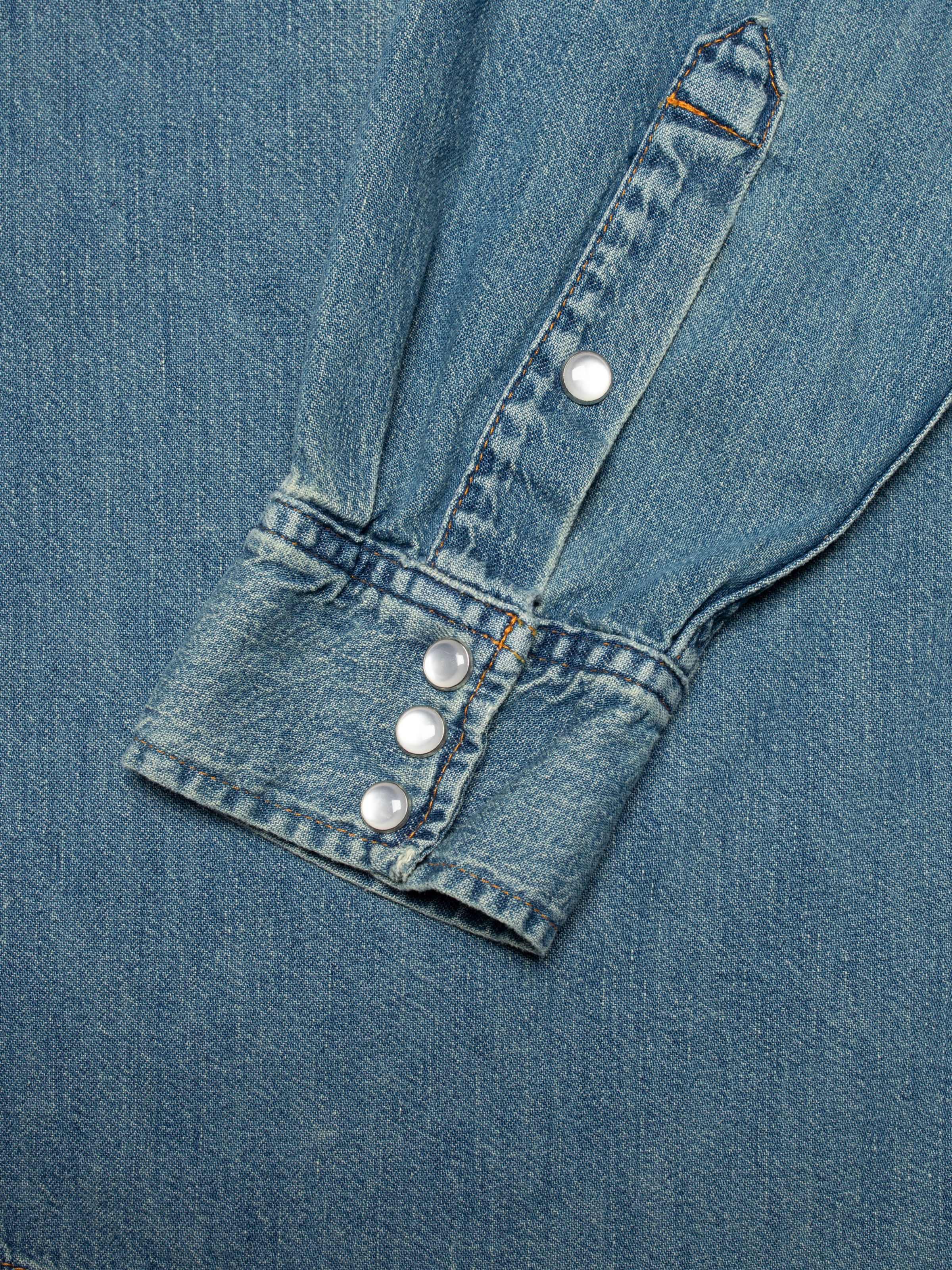 Nudie Jeans Gunnar Denim Shirt Clean Wash, close-up of the sleeve cuff showing the white glass snap buttons.