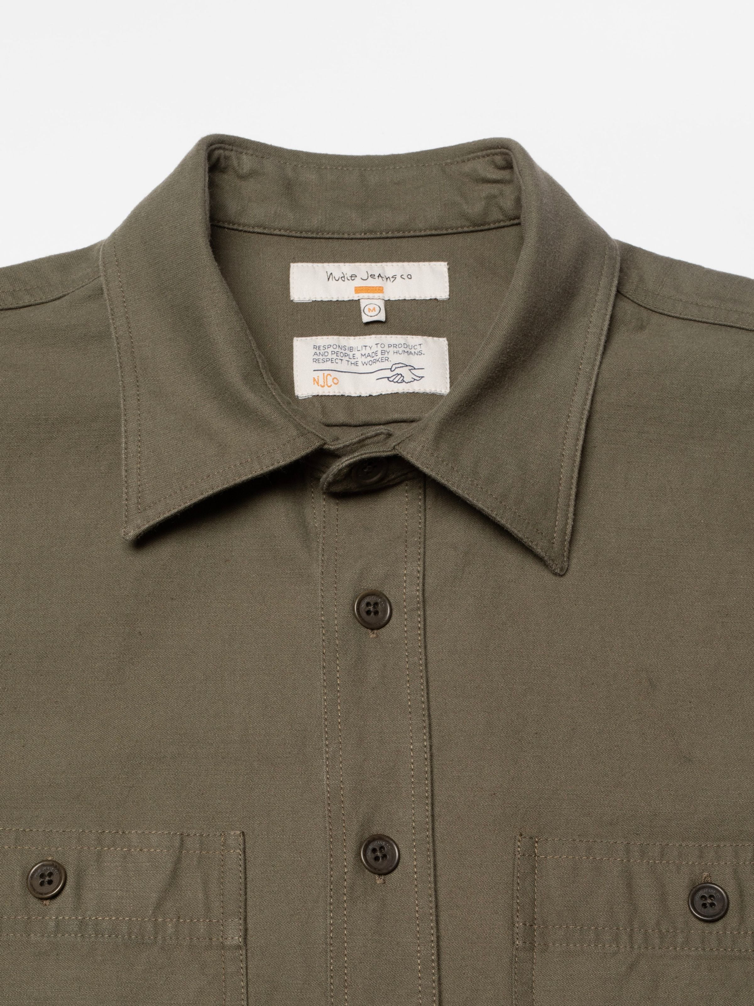 Nudie Jeans Julian Shirt Back Sateen in Olive Green, showing a close-up of the collar, corozo buttons, and brand labels.
