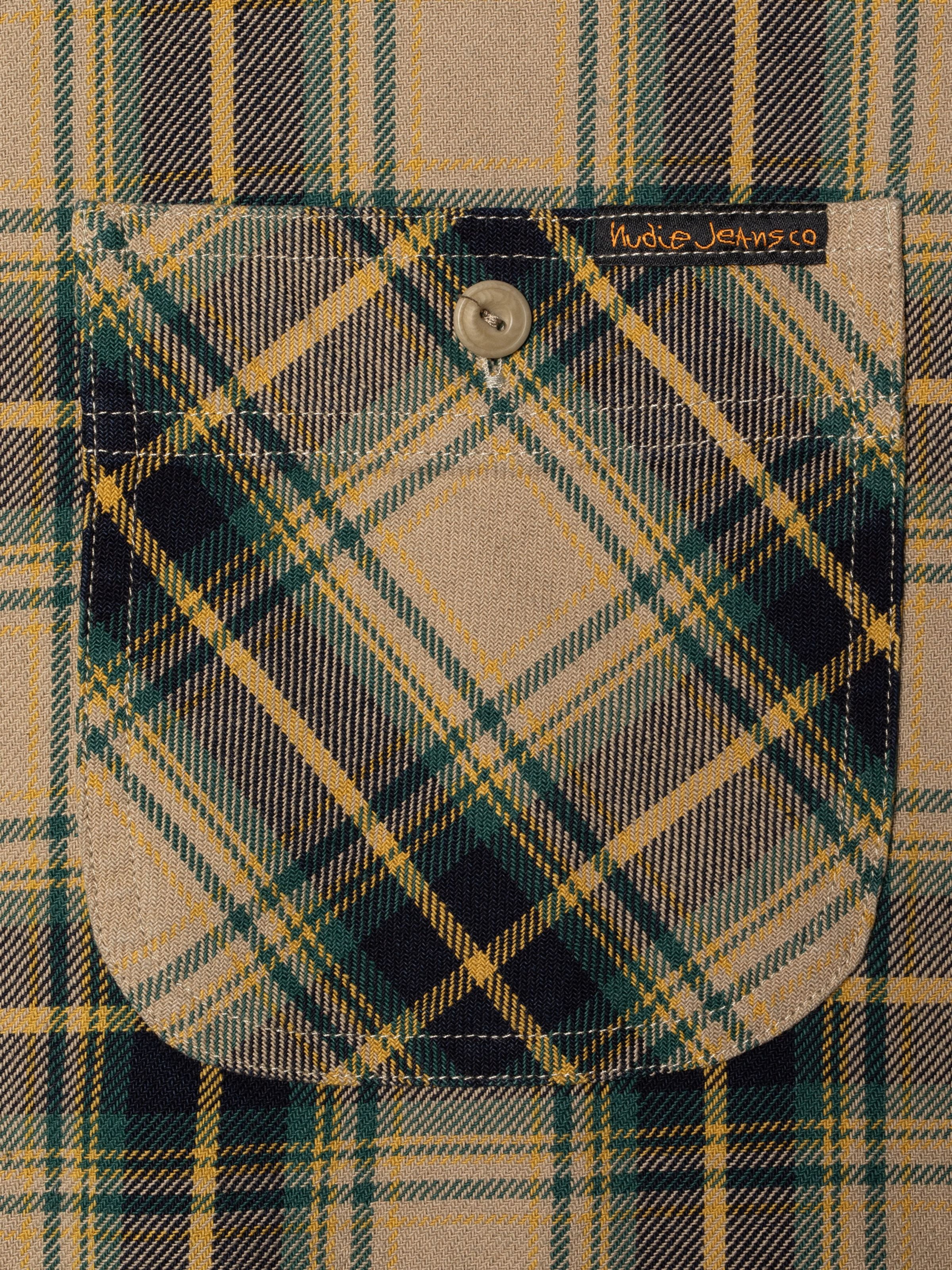 Nudie Jeans Julian Shirt Tartan Check, close-up of the chest pocket and corozo button in organic cotton twill.